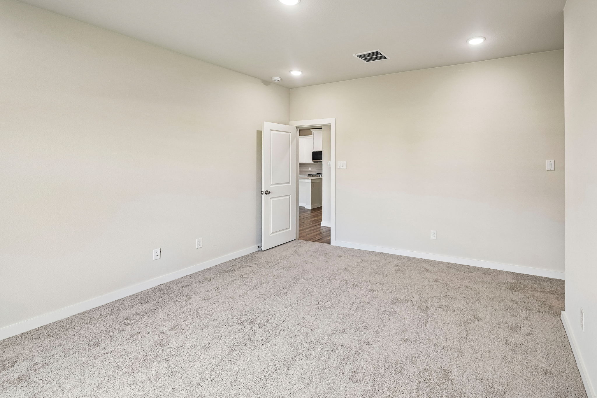 A room with a carpet and a door.