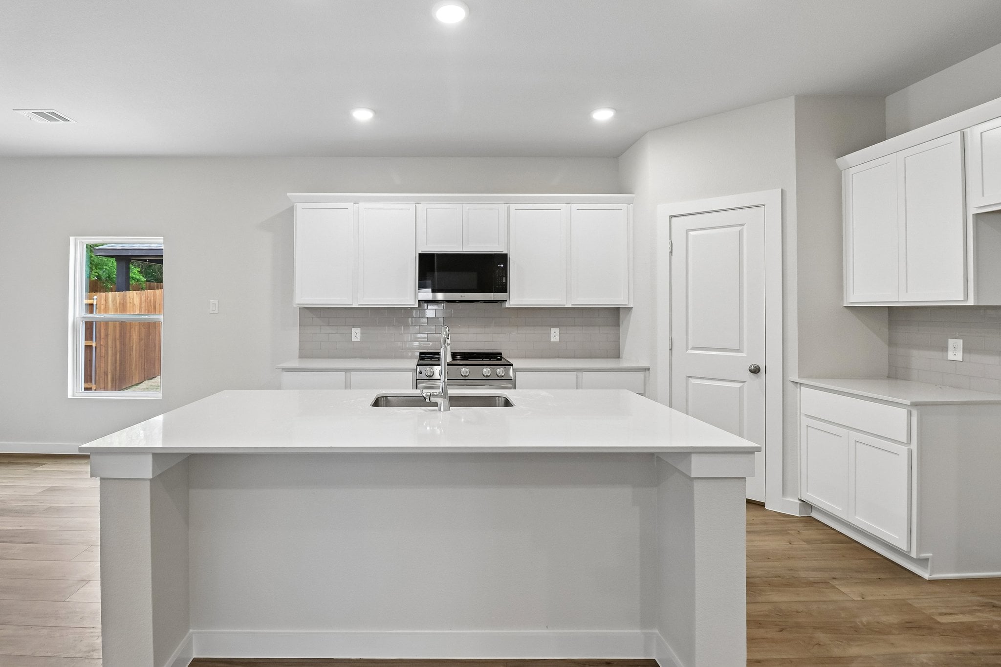 A kitchen with white cabinets.