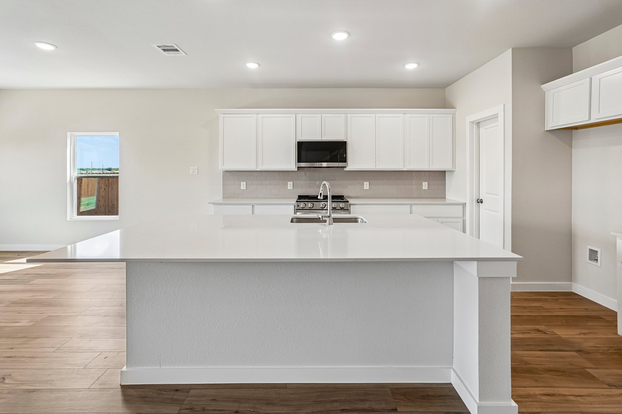 A kitchen with white cabinets.