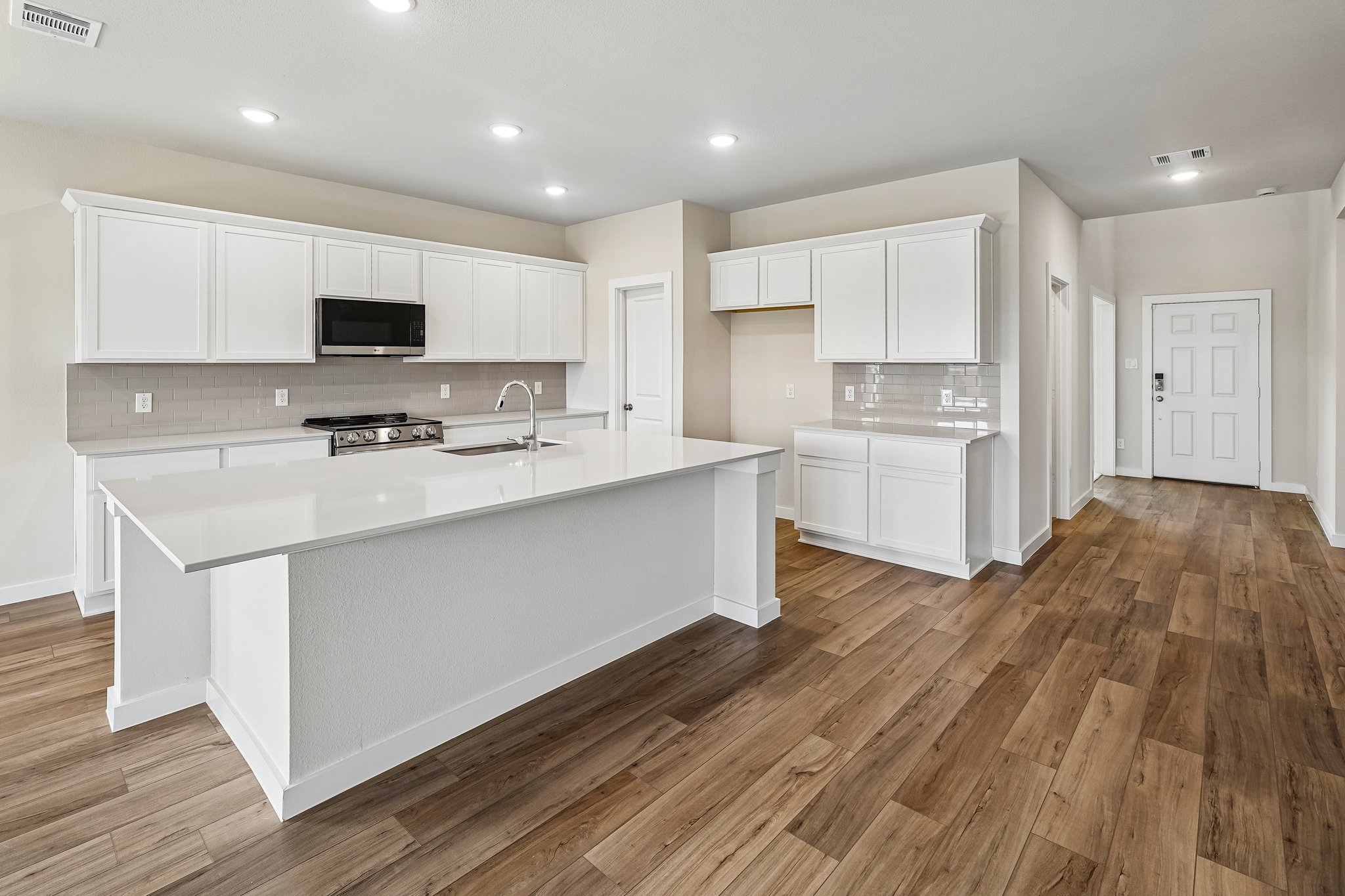 A kitchen with white cabinets.