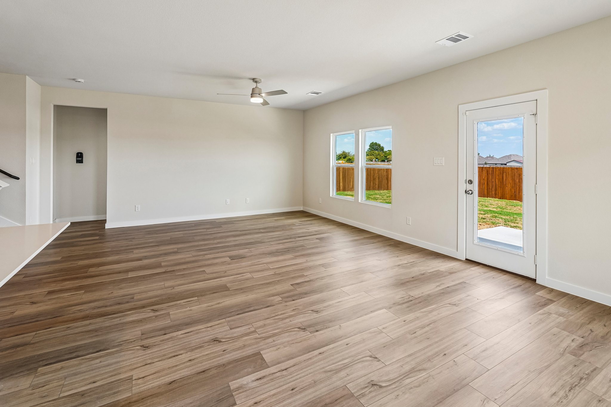 A room with a wood floor and windows.