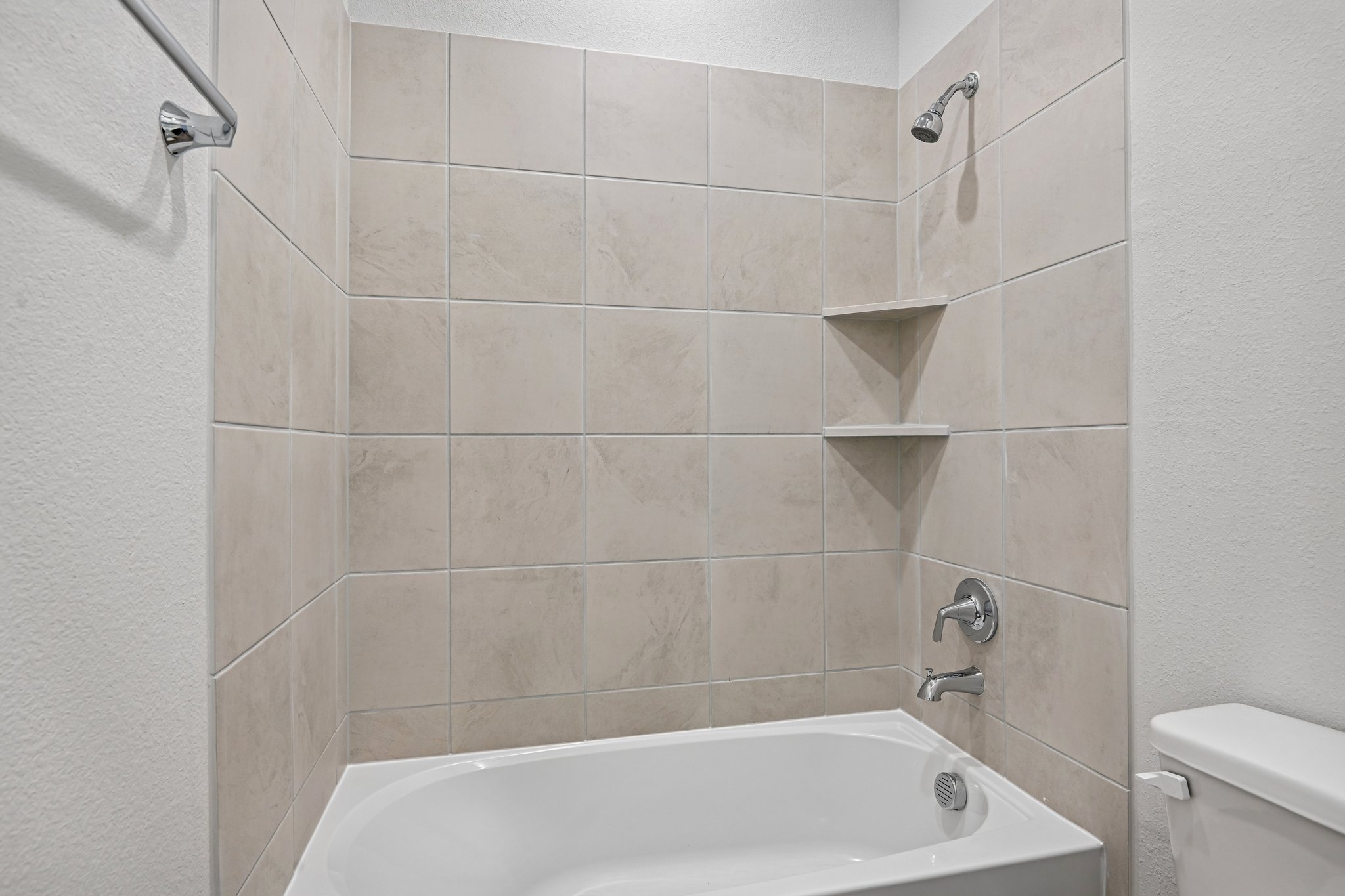 A bathroom with a bathtub and toilet.
