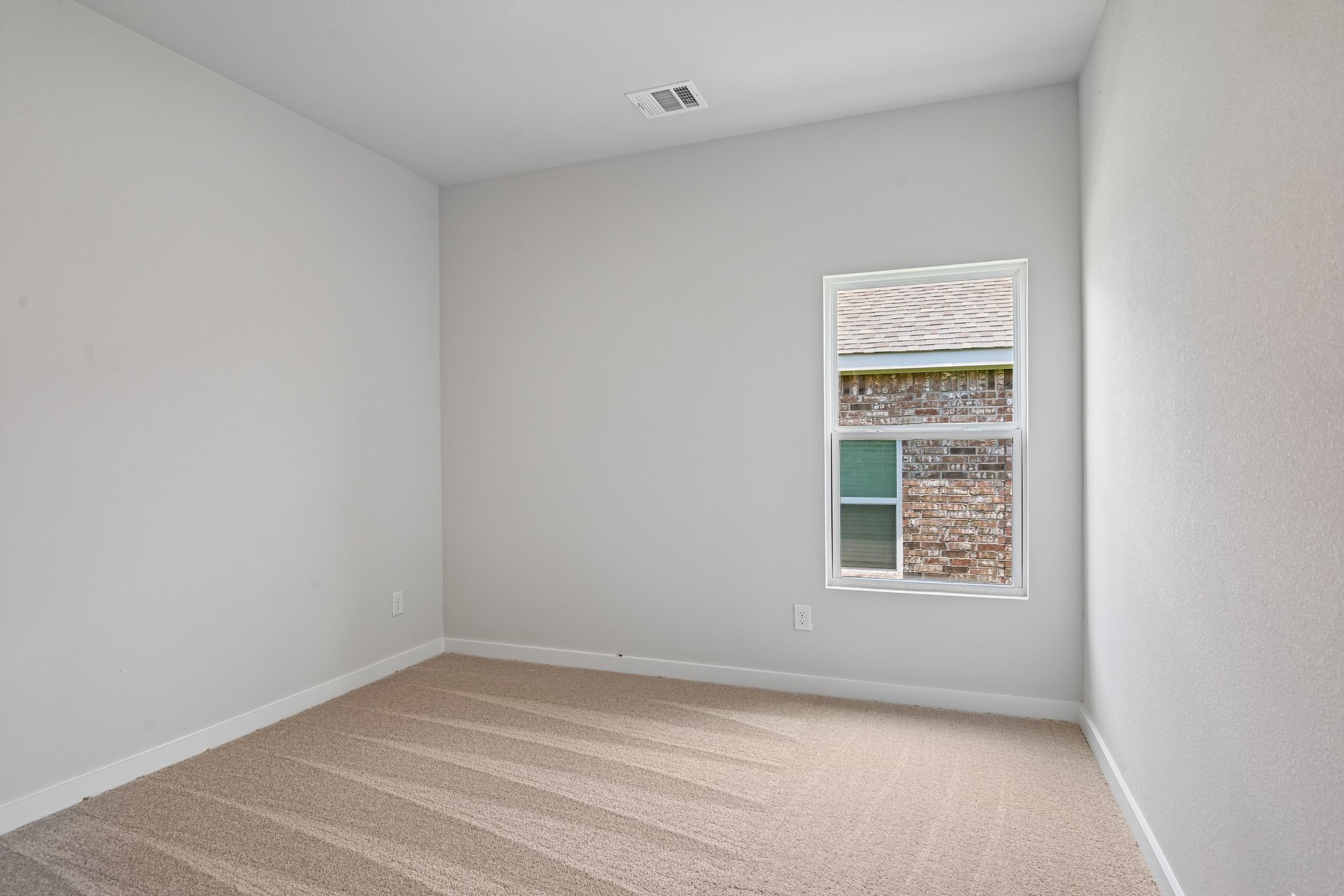 A room with a window and a carpet.