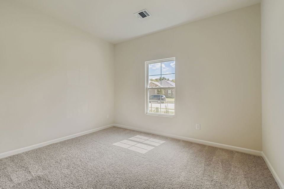 A room with a window and a rug.