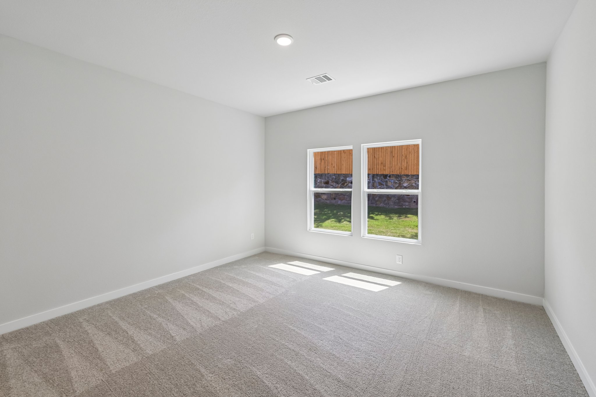 A room with a window and carpet.