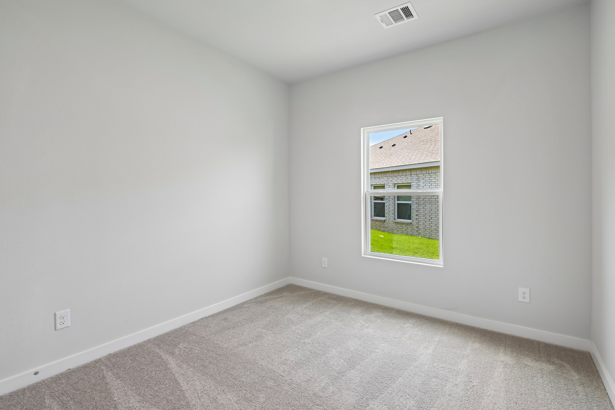 A room with a window and a carpet.