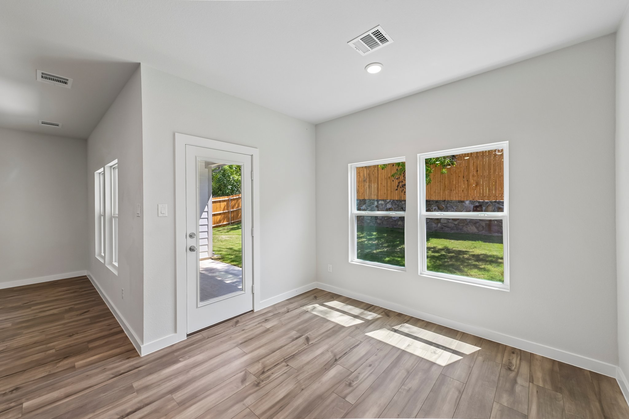 A room with a wood floor and windows.