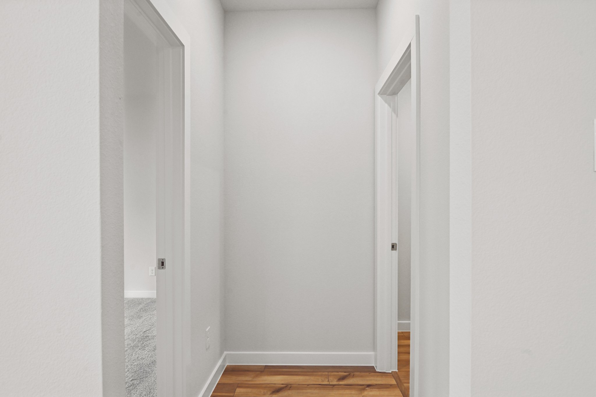 A white hallway with white doors.