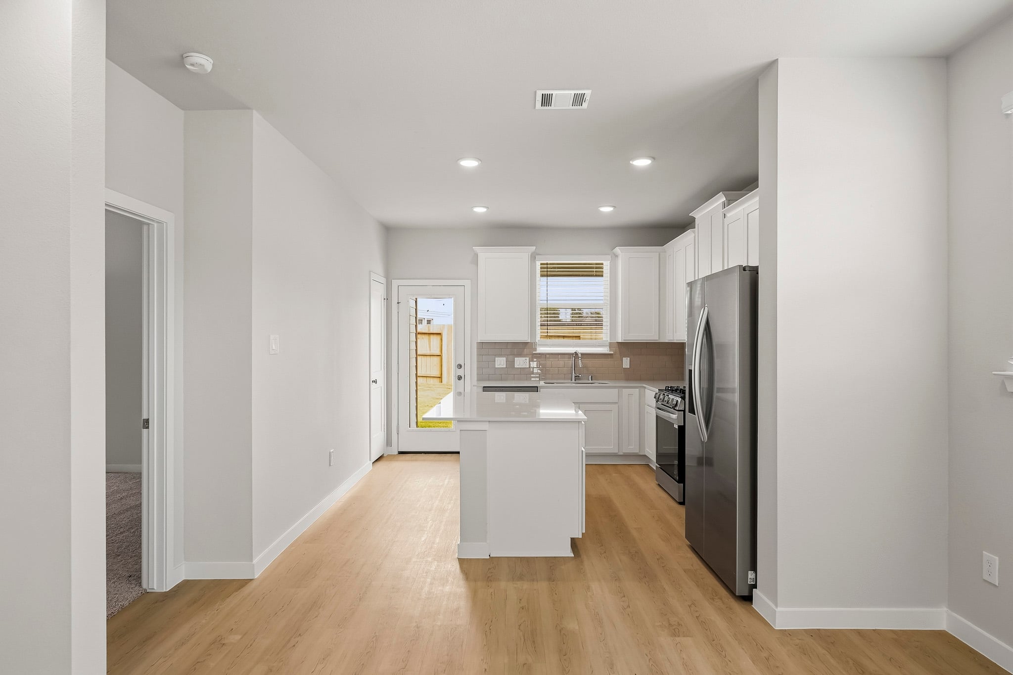 A kitchen with white cabinets.