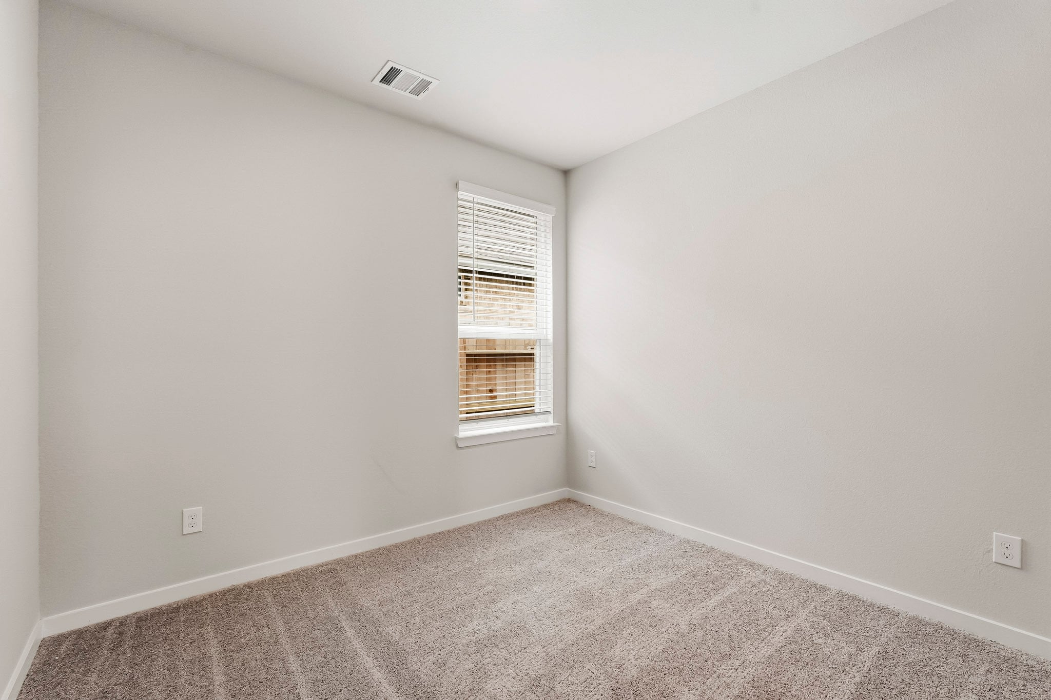 A room with a window and carpet.