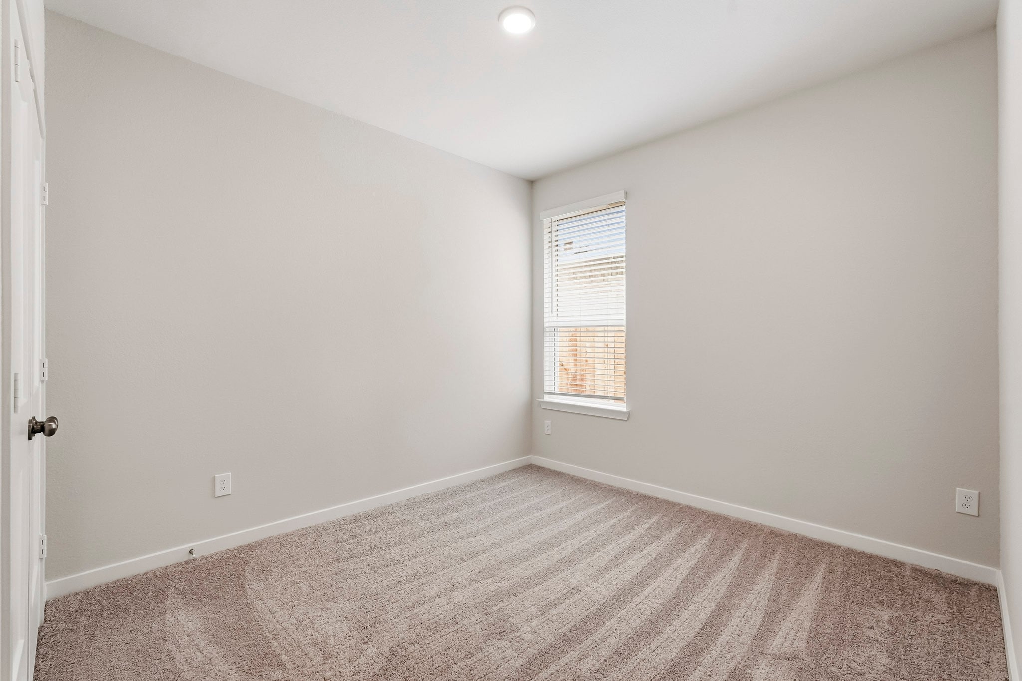 A room with a carpet and a window.