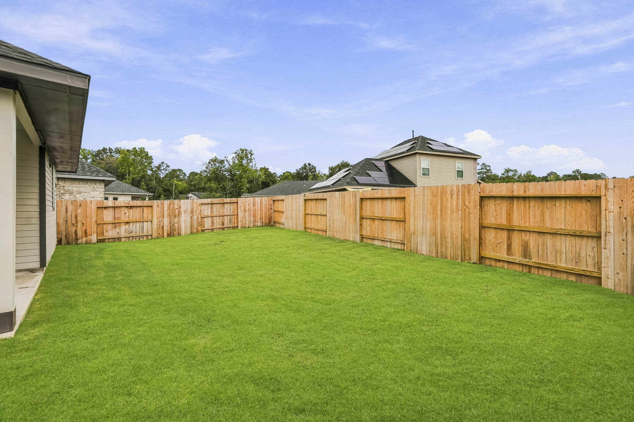 A fenced in yard with a house in the background.