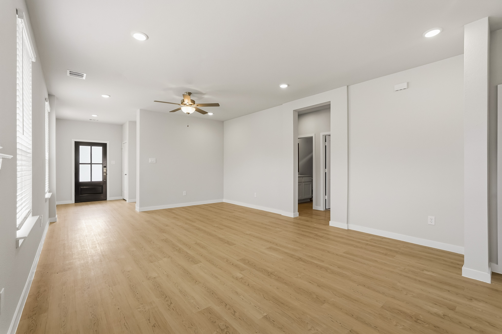 A room with a wood floor and a ceiling fan.
