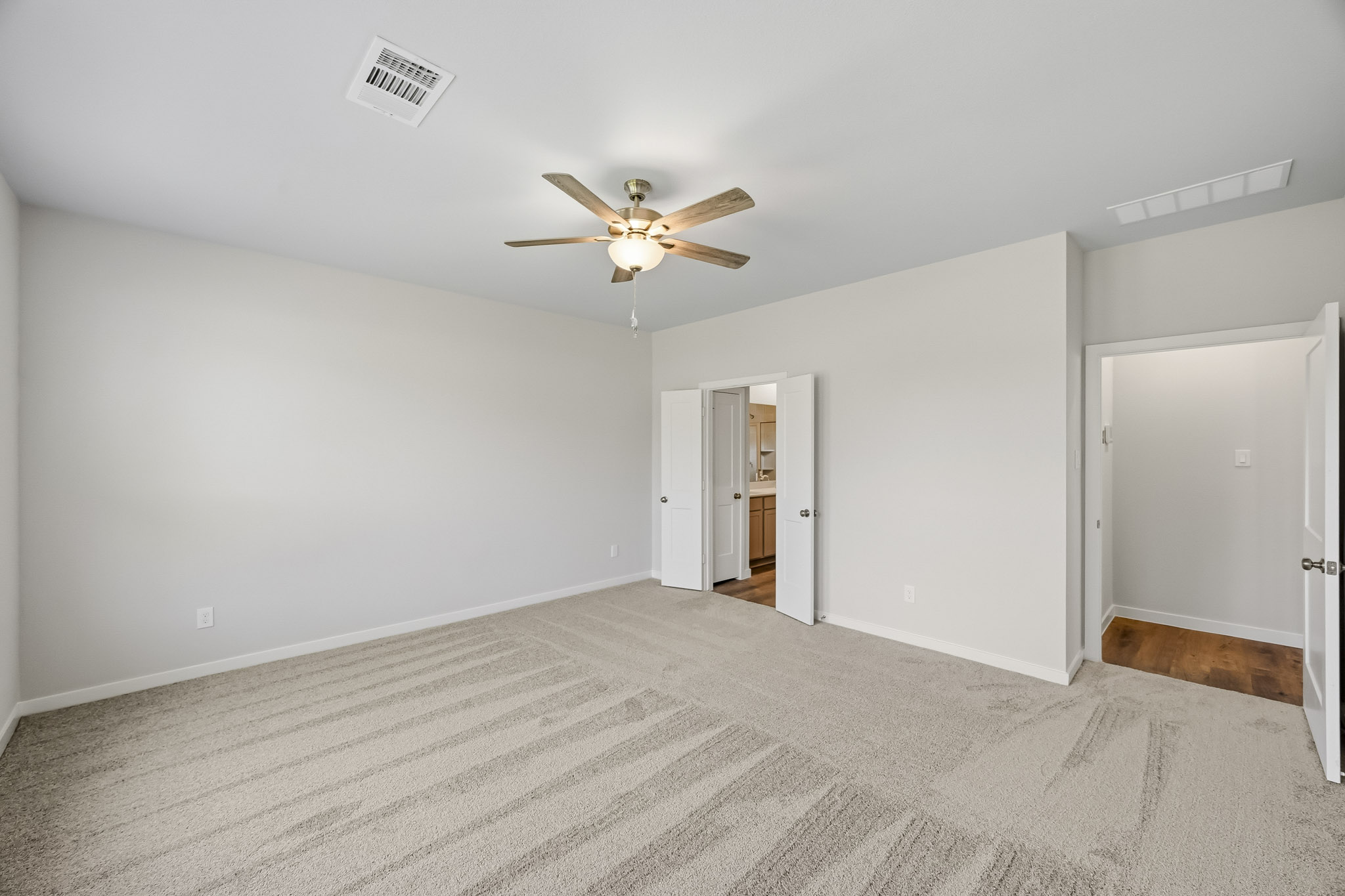 A room with a ceiling fan and a door.