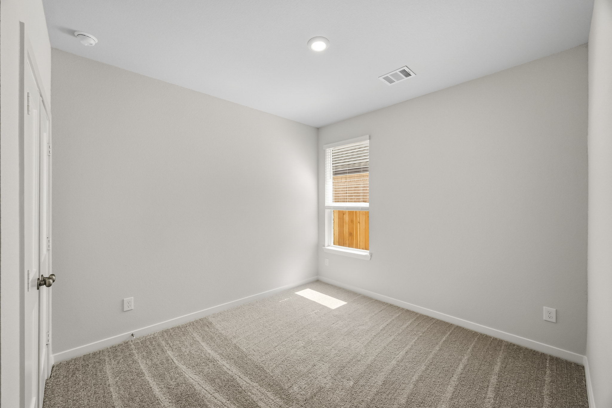 A room with a carpet and a window.