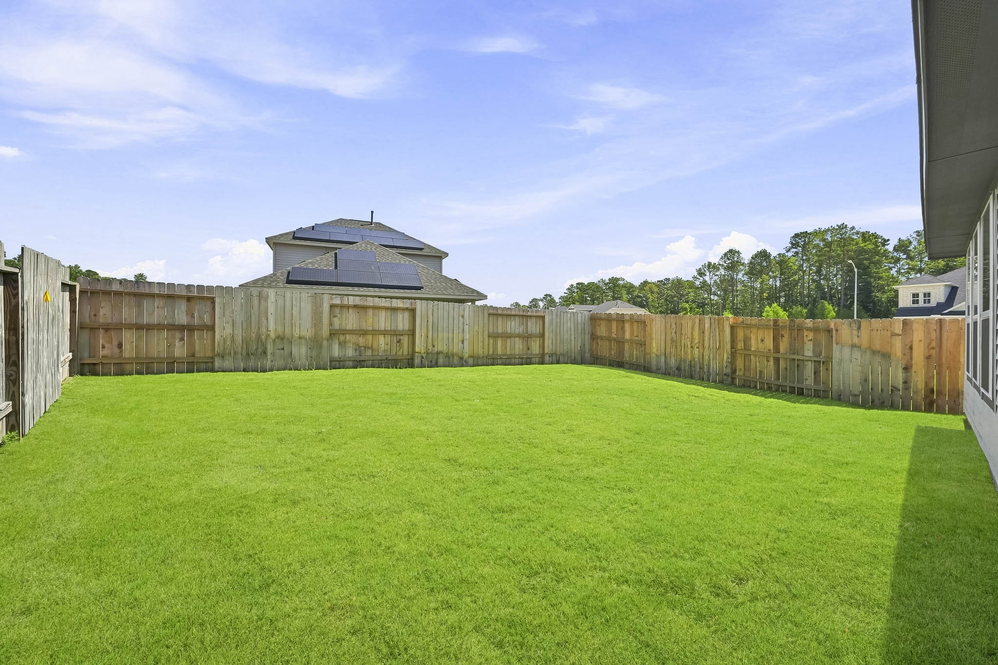 A fenced in yard with a house in the background.