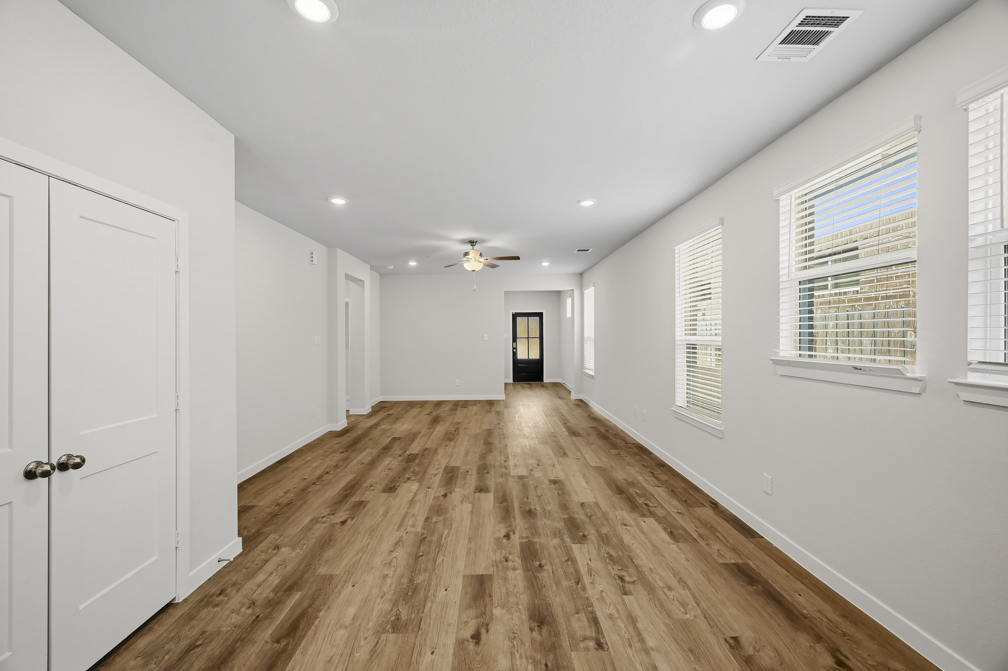 A long hallway with white doors.