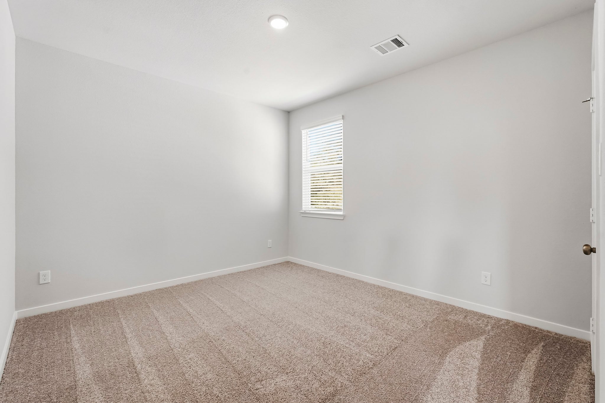 A room with a carpet and a window.