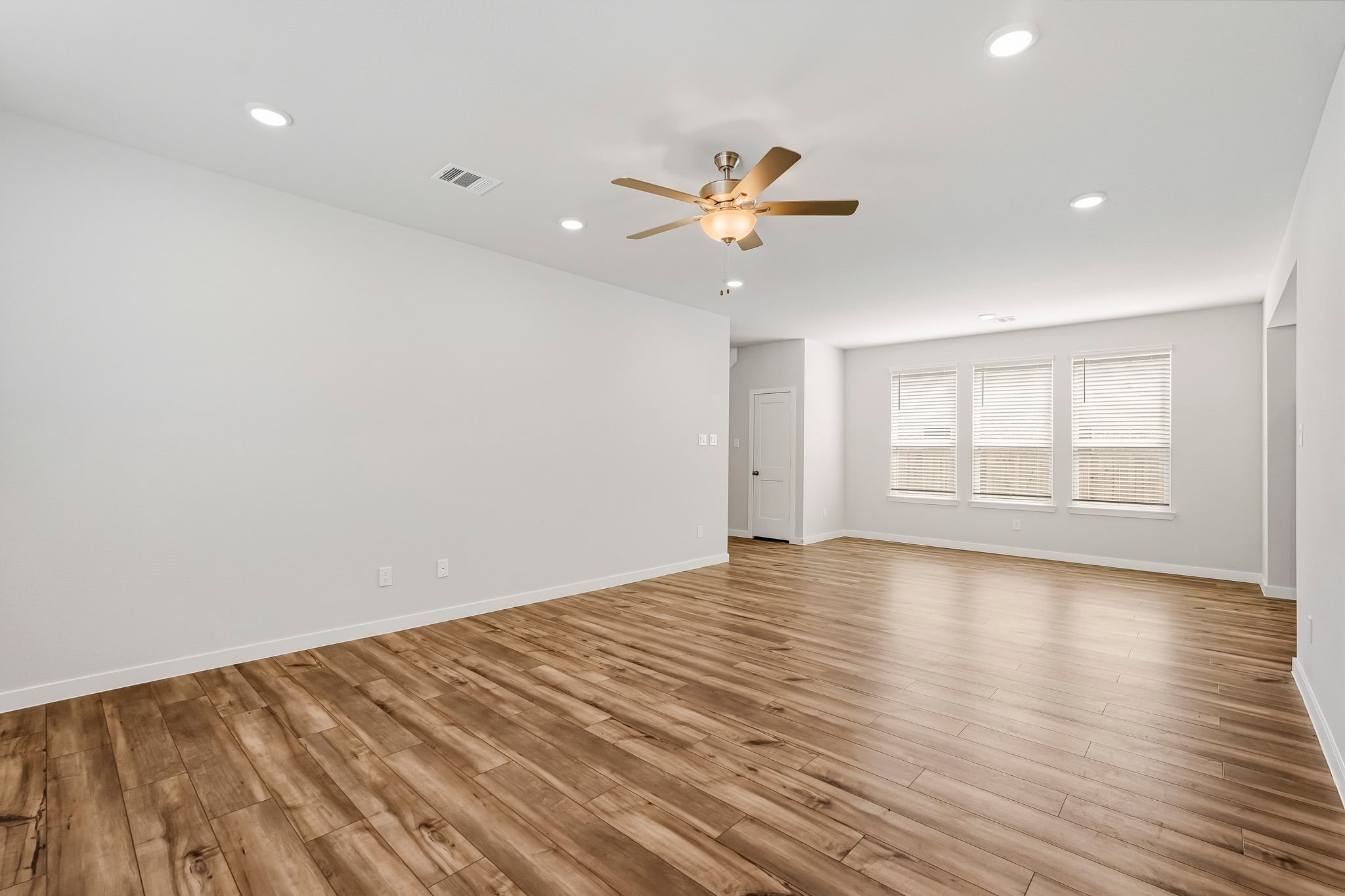 A room with a wood floor and a ceiling fan.