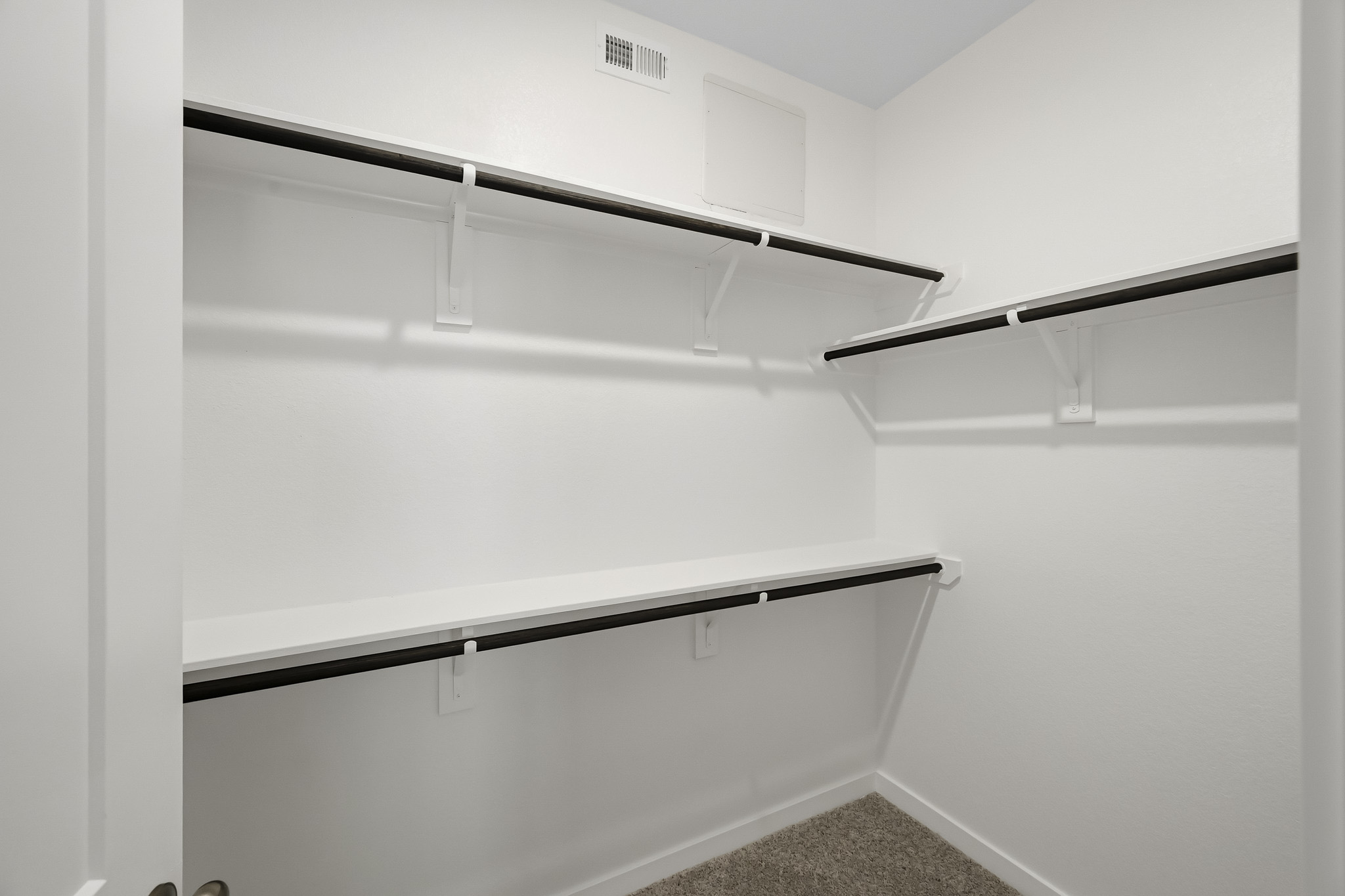 A white wall with a metal bar.