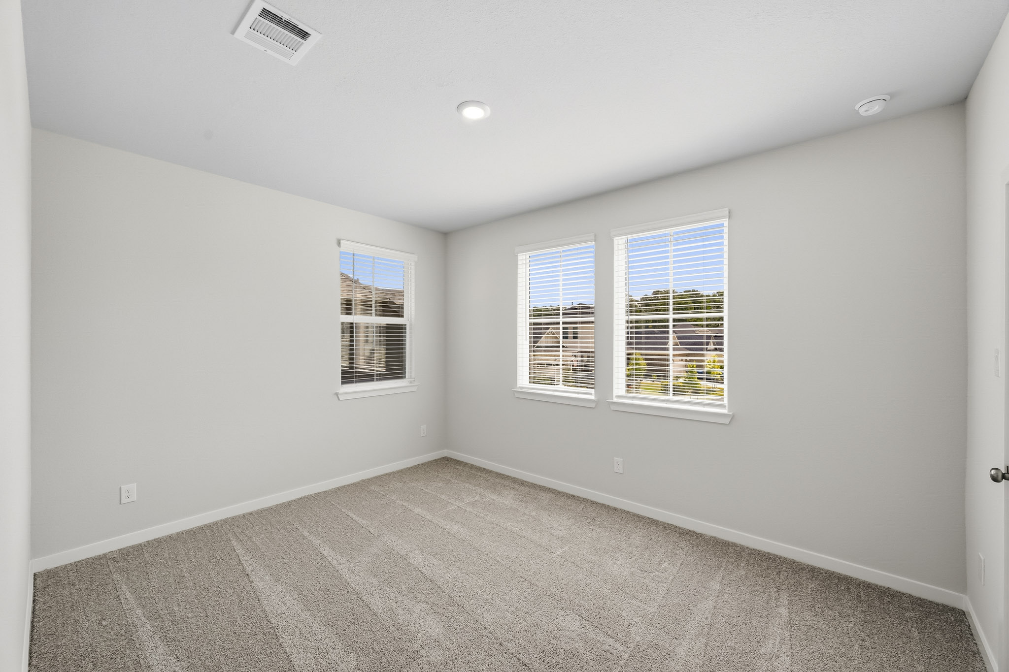 A room with a carpet and windows.