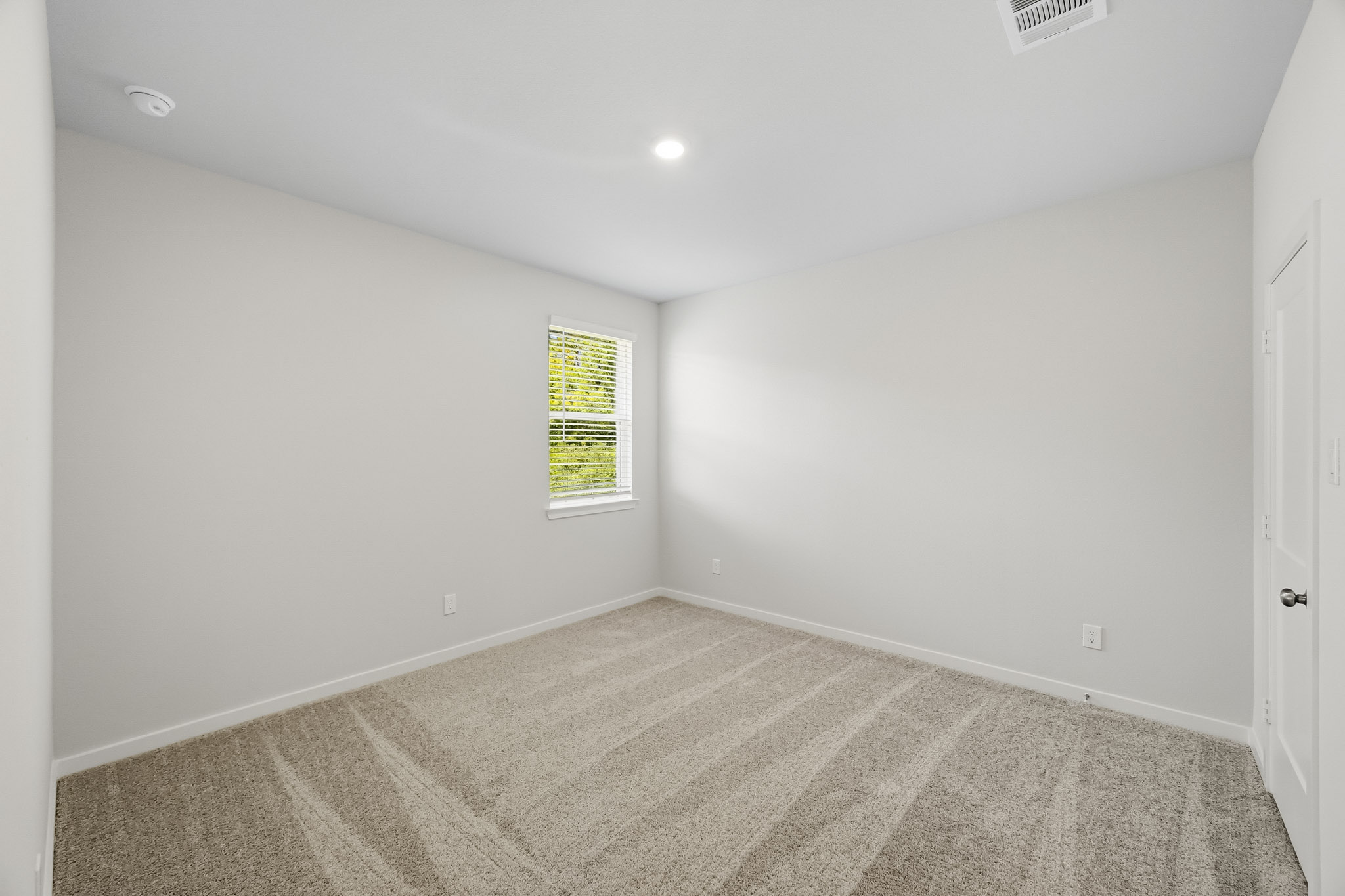 A room with a carpet and a window.
