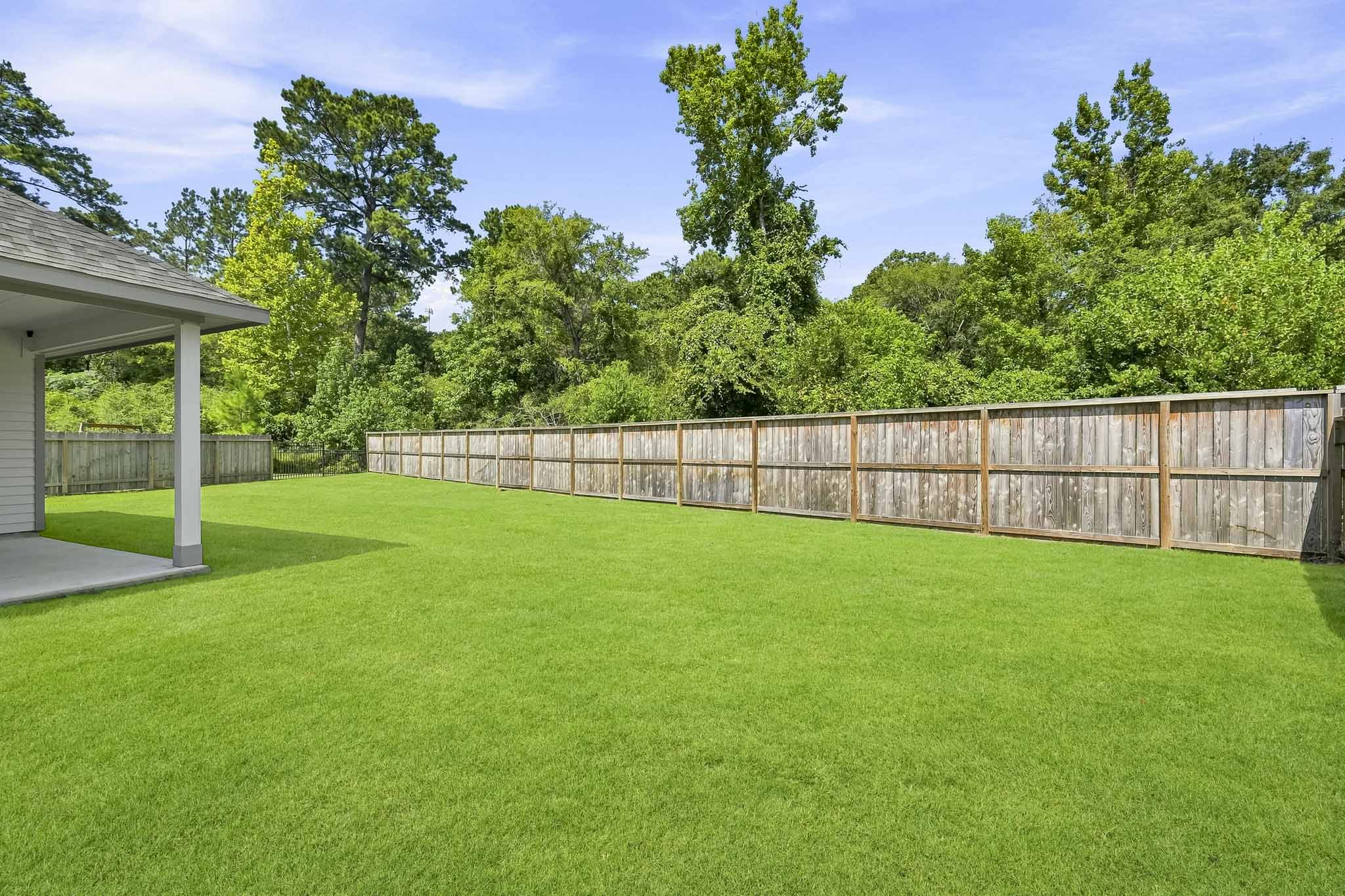 A fenced in yard with trees.