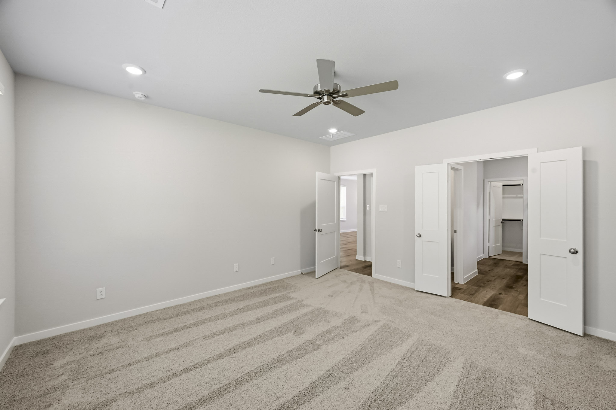 A room with white walls and a ceiling fan.