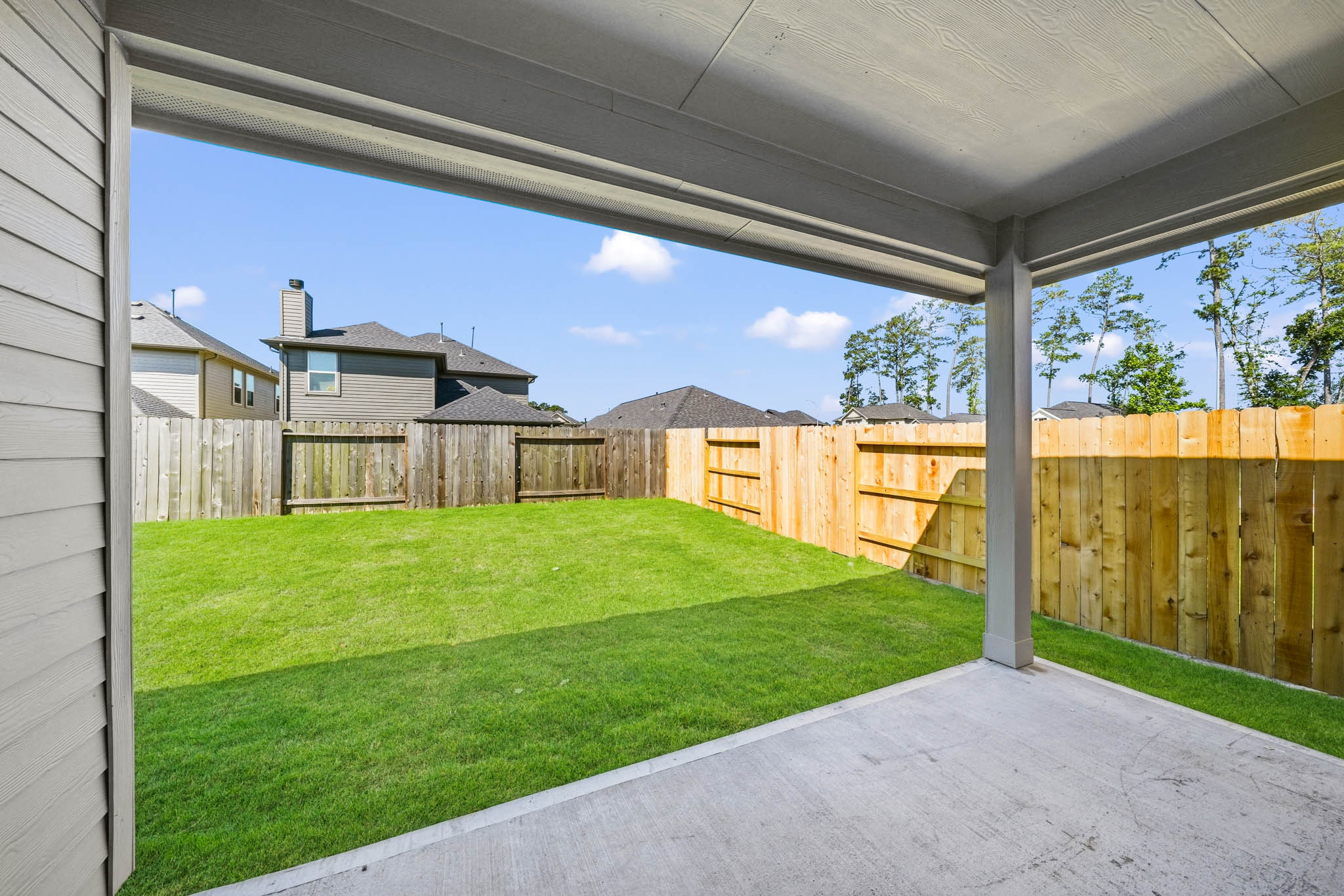 A fenced in yard with a house in the background.