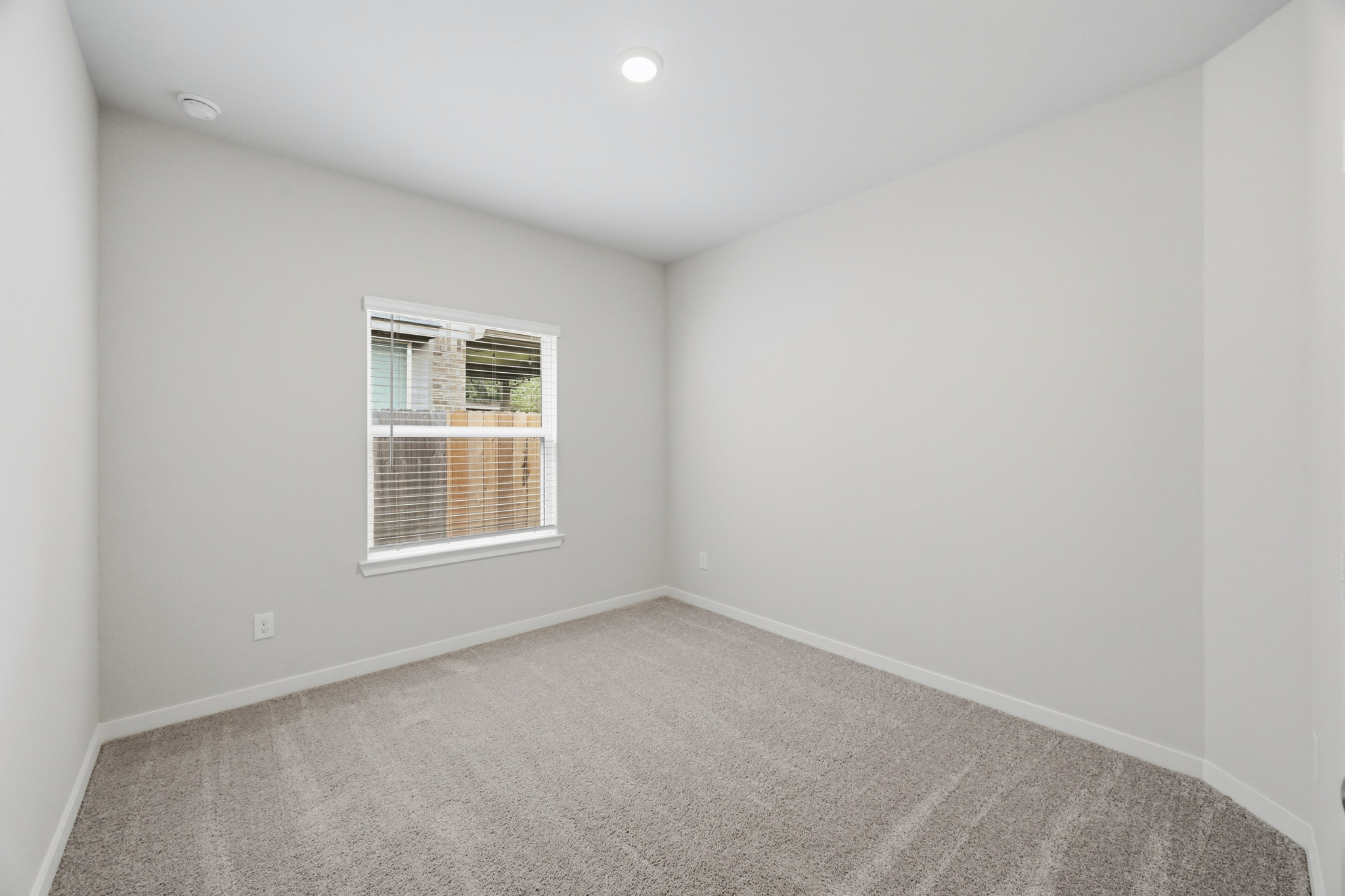 A room with a window and carpet.
