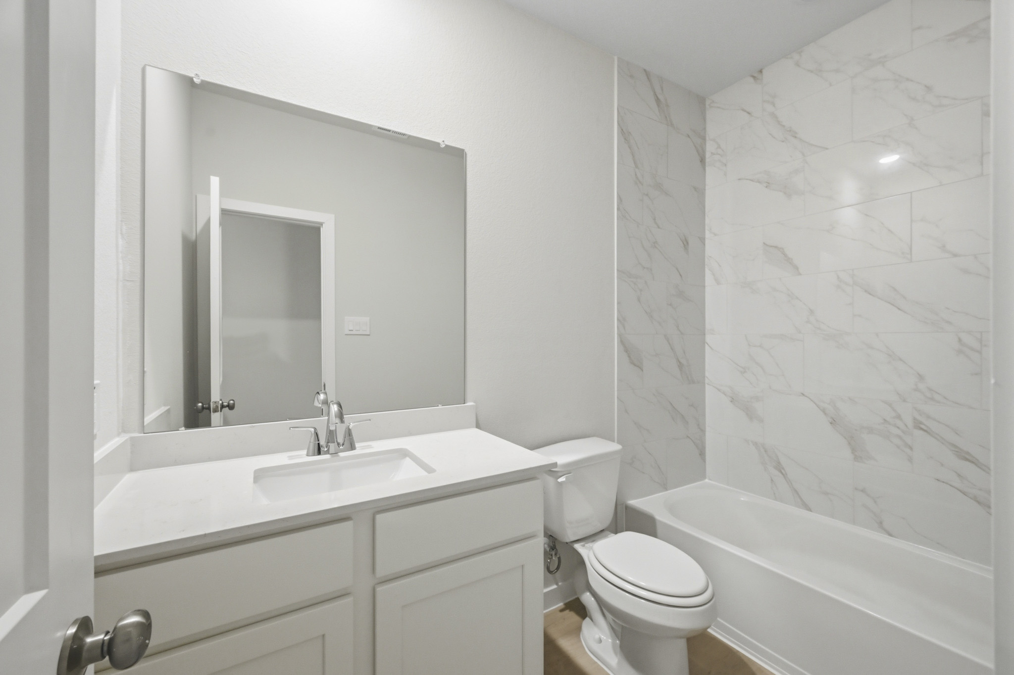 A bathroom with a sink toilet and bathtub.