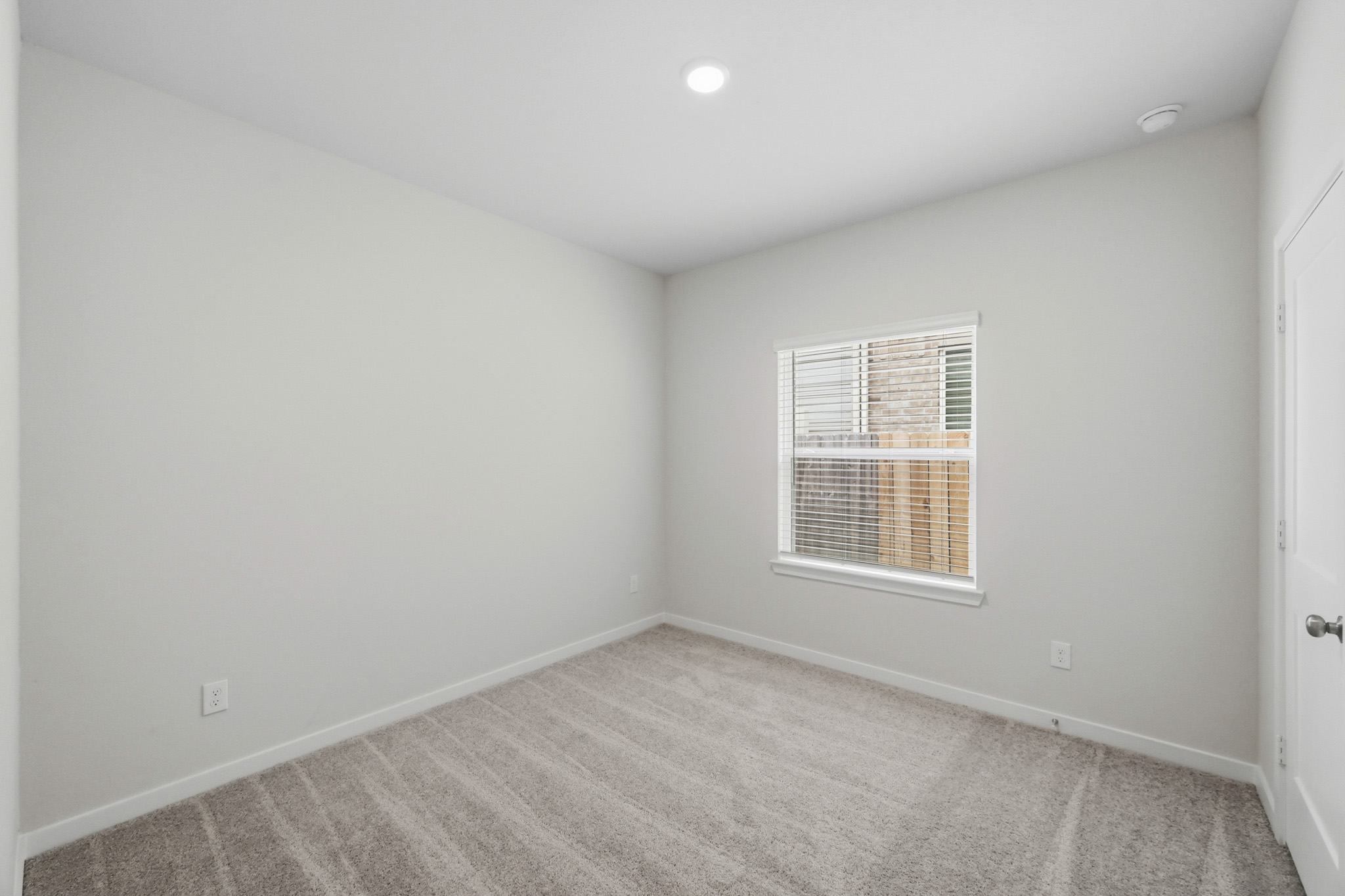 A room with a window and a rug.