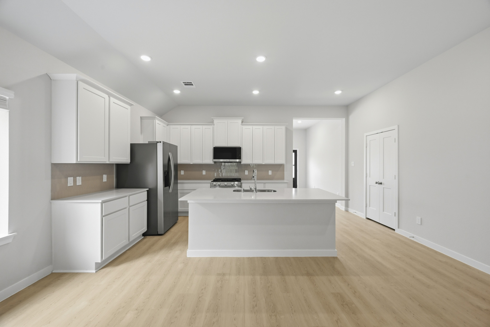 A kitchen with white cabinets.