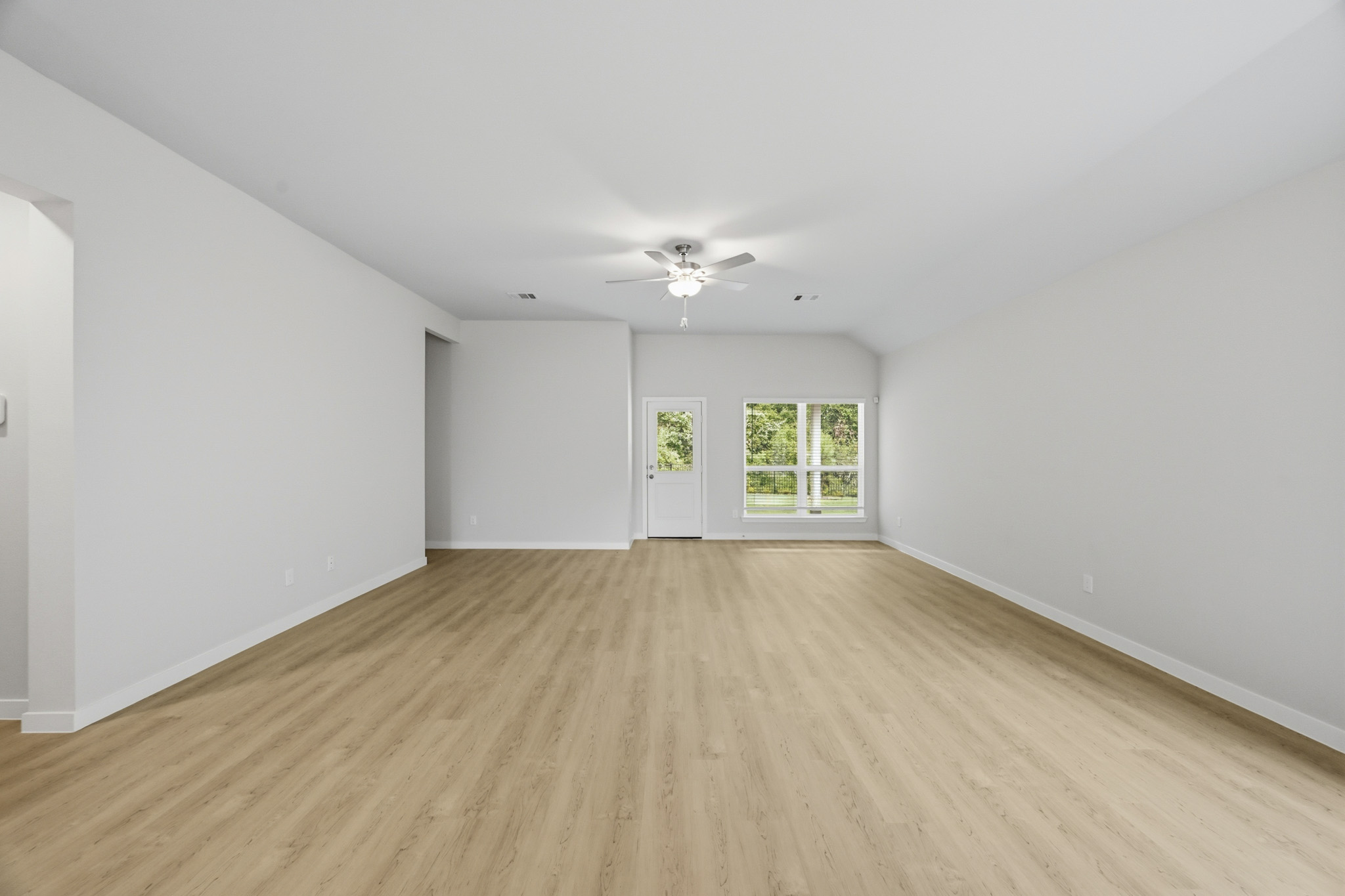 A room with a wood floor and a ceiling fan.