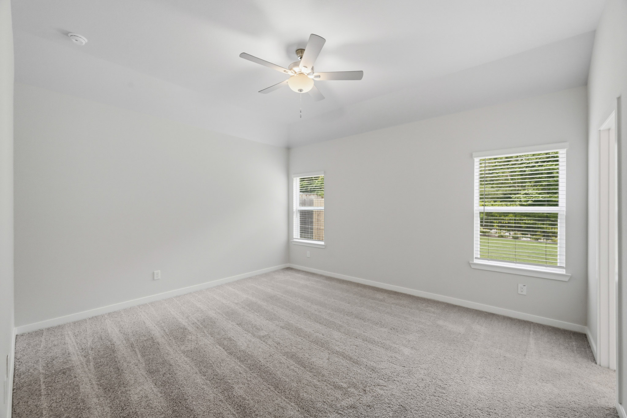 A room with a ceiling fan and a window.