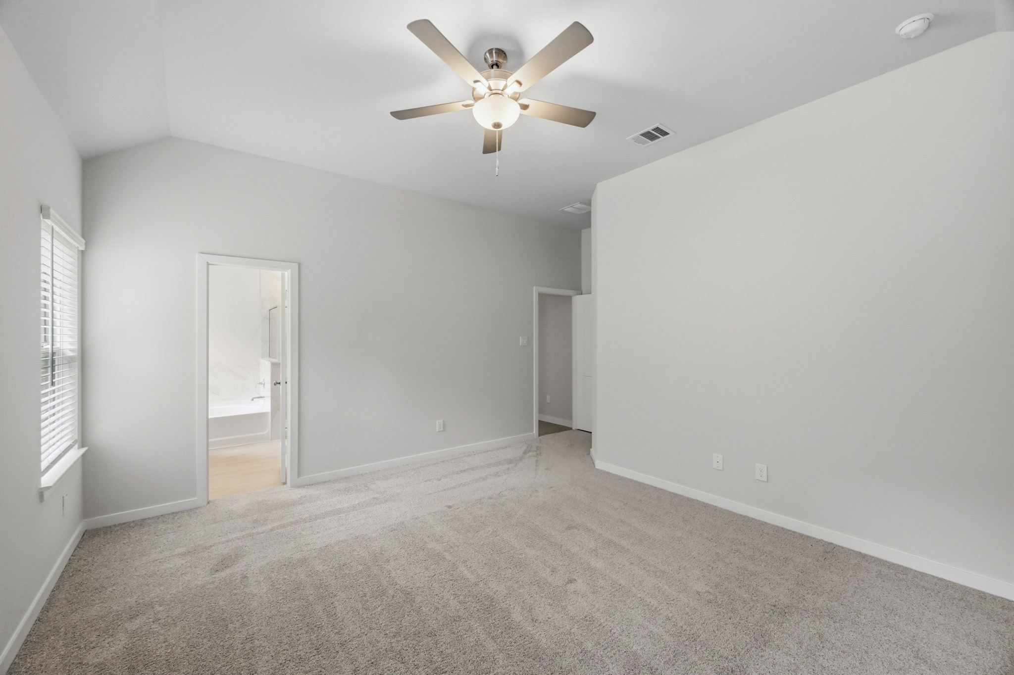 A room with a ceiling fan and a door.