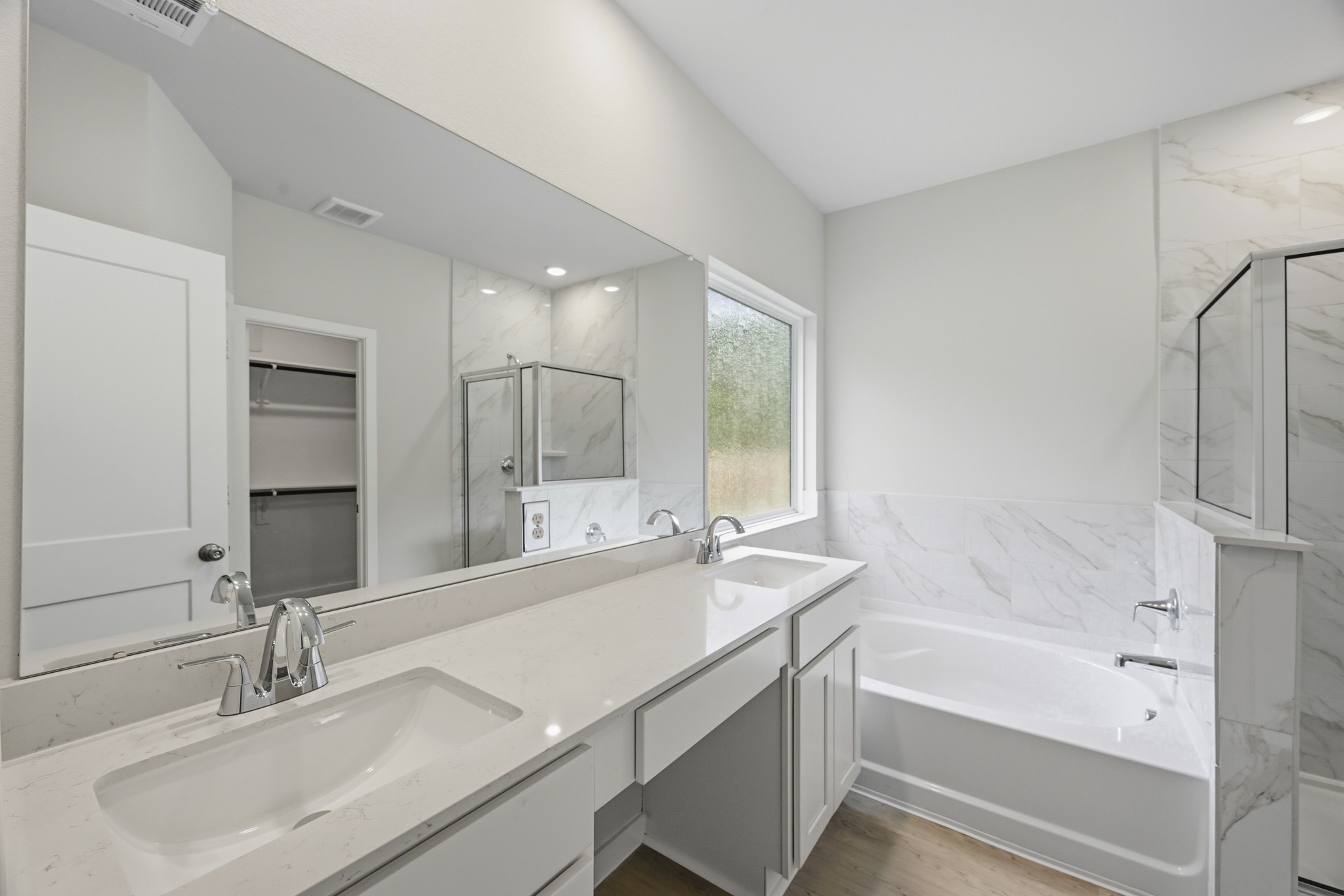 A bathroom with a tub sink and a mirror.