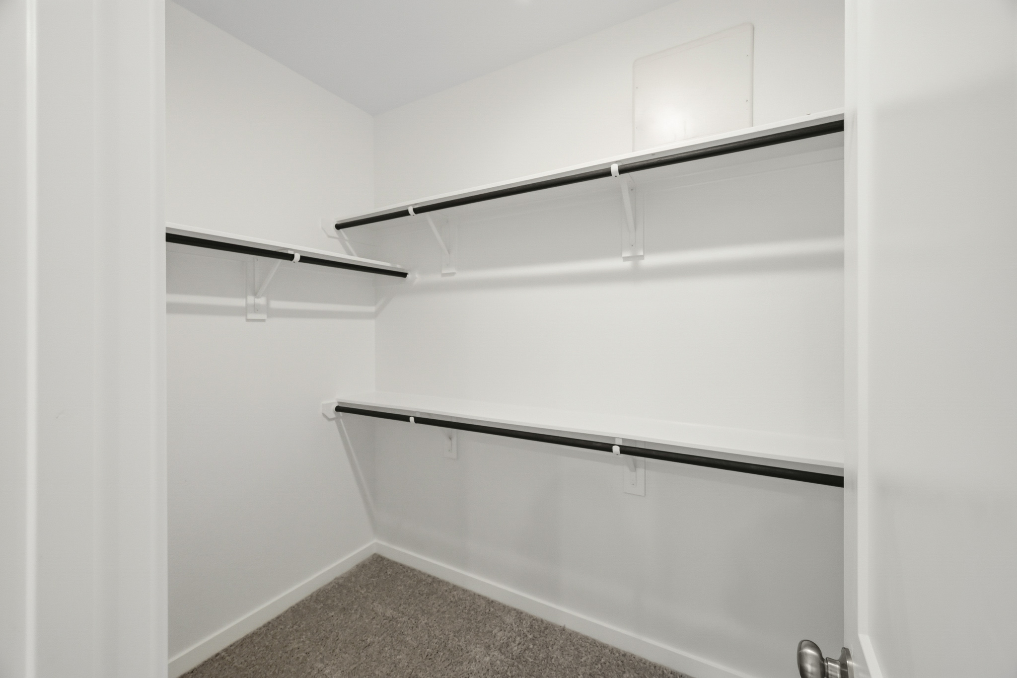 A white wall with a metal shelf.