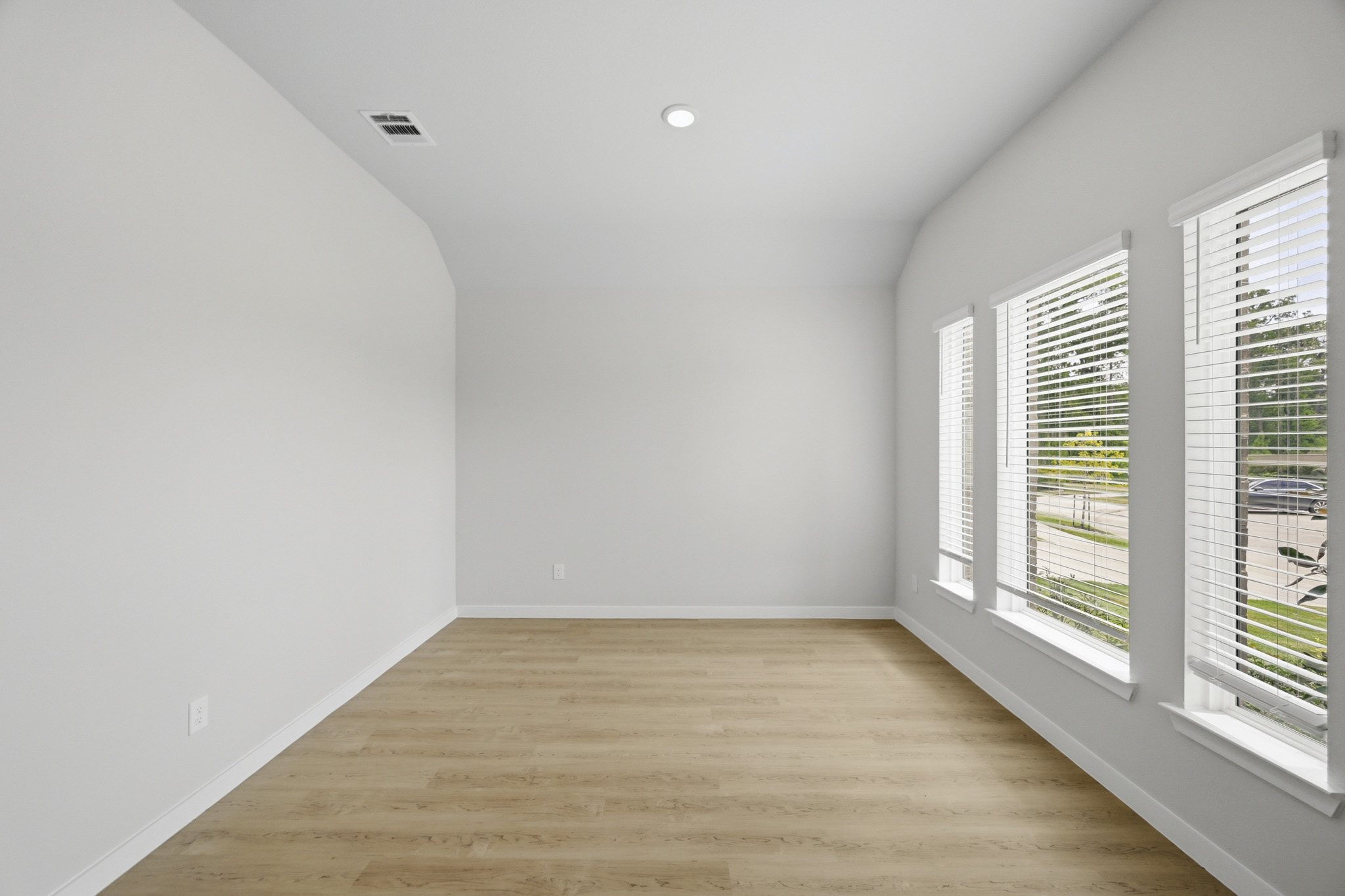 A room with a wood floor and windows.