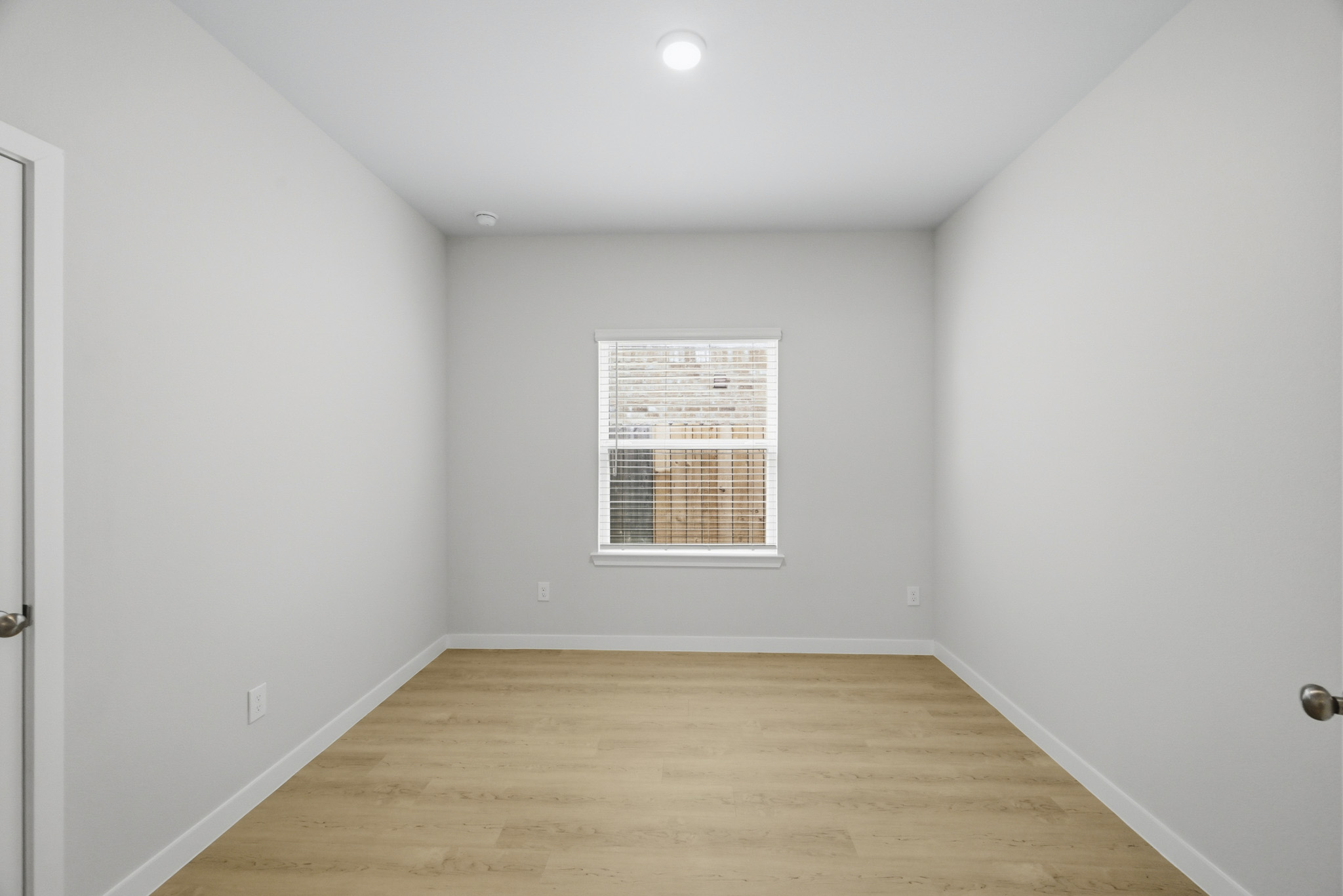 A room with a wood floor and a window.
