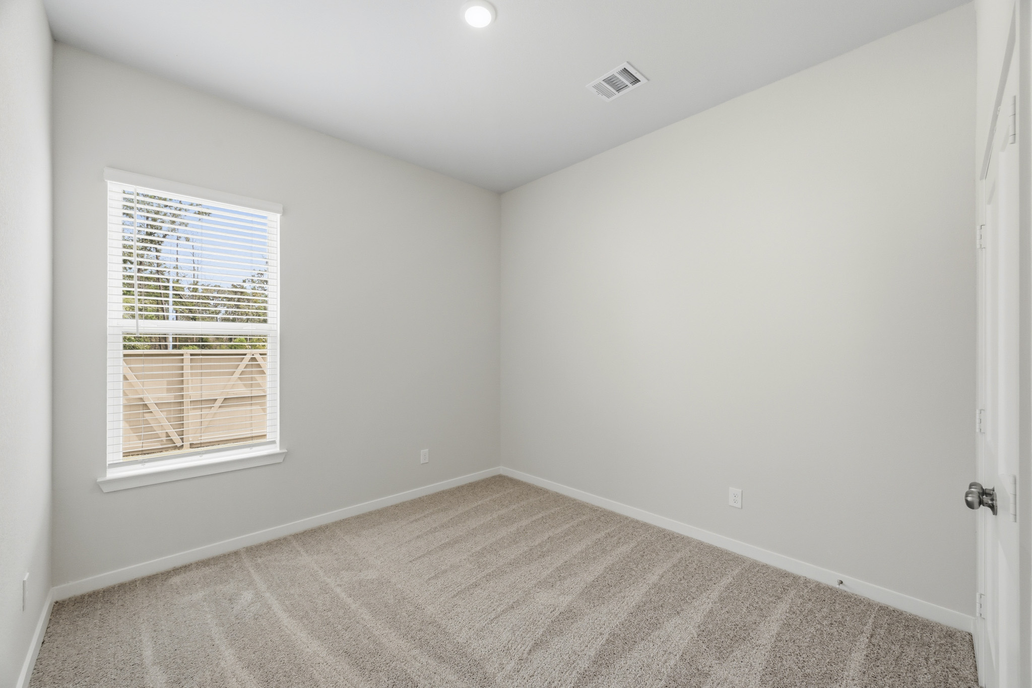 A room with a window and a rug.