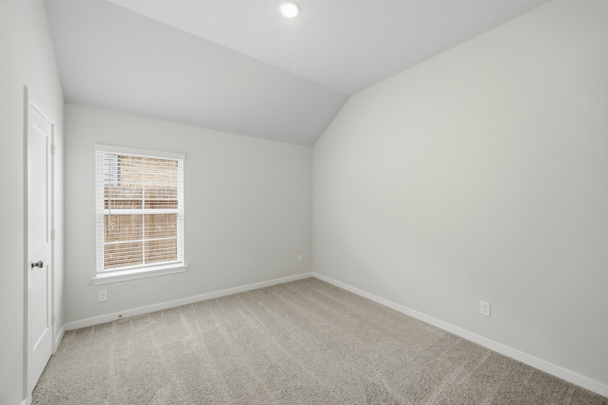 A room with a window and a carpet.