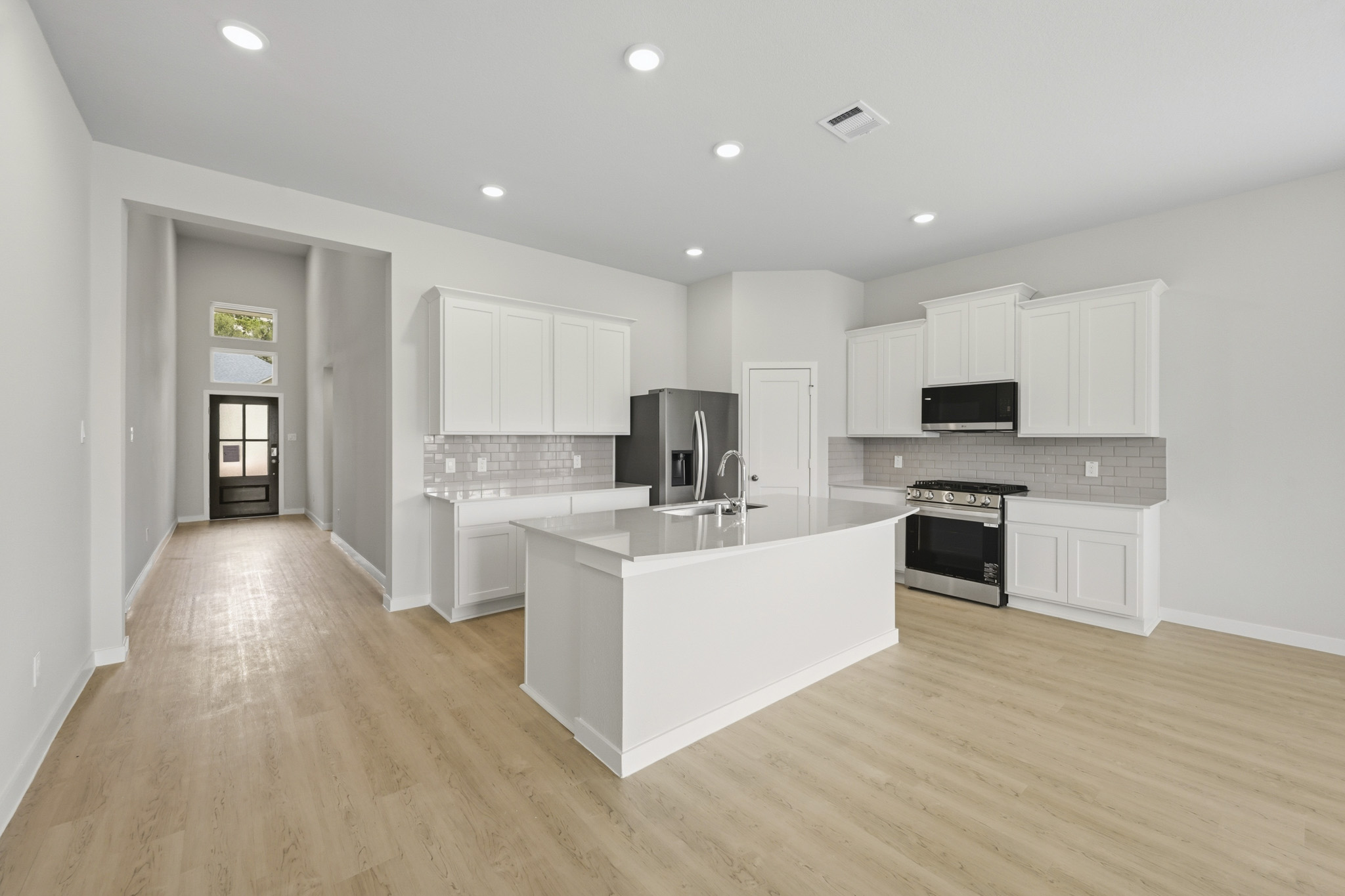 A kitchen with white cabinets.