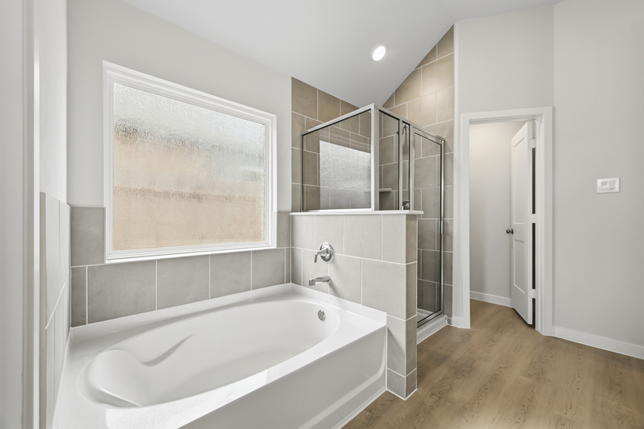 A bathroom with a tub and a mirror.