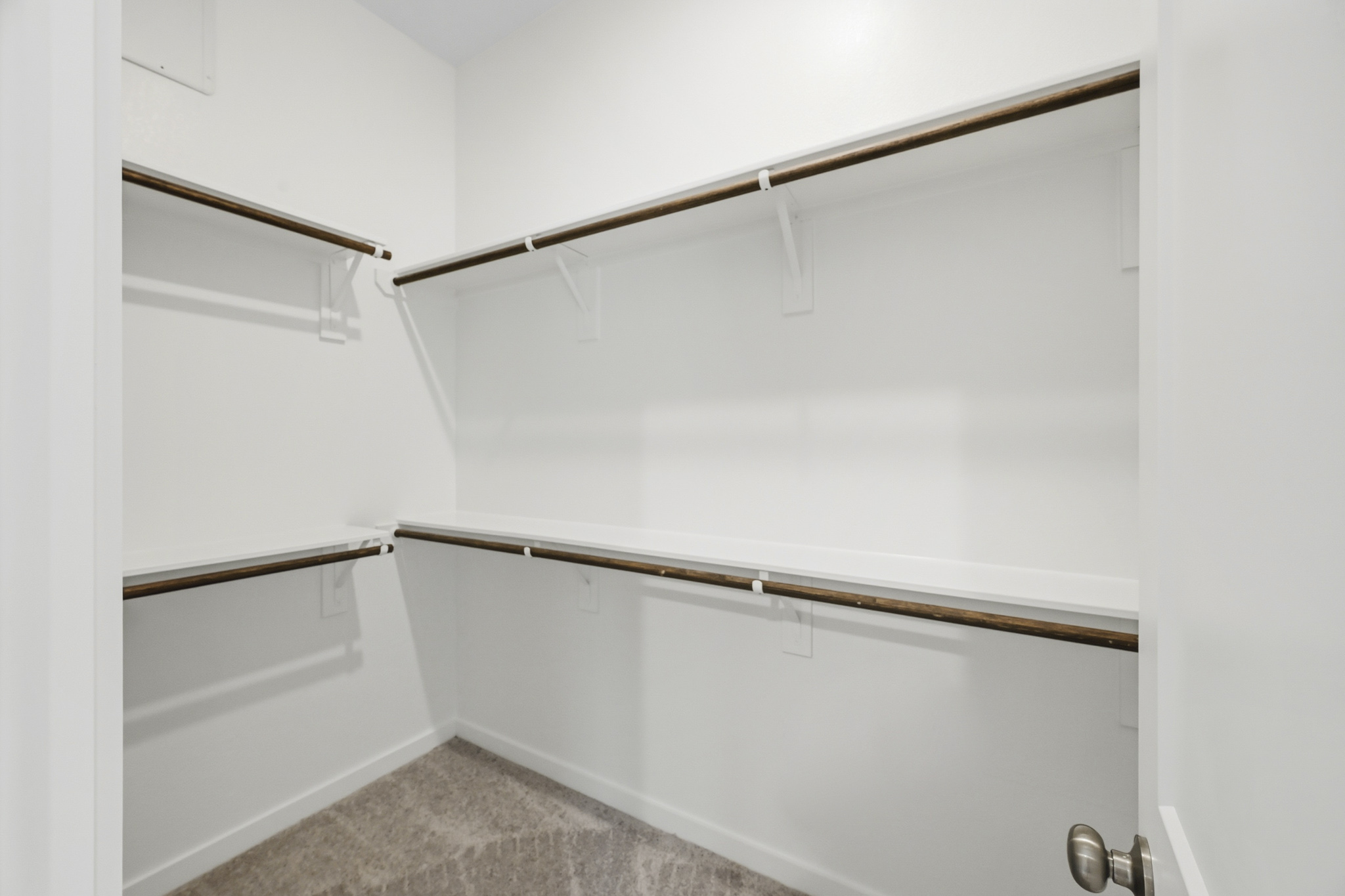 A white wall with a metal bar.