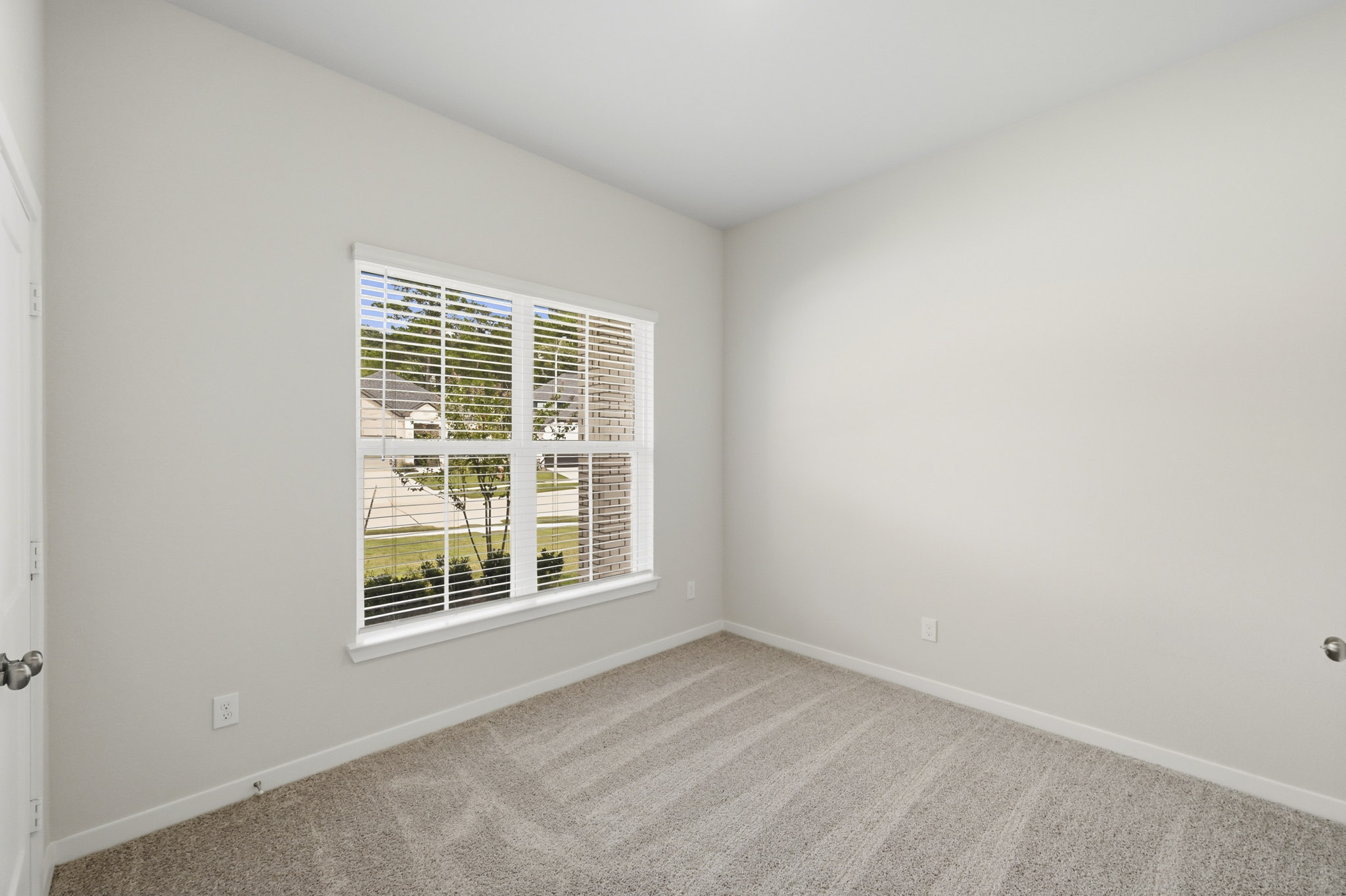 A room with a window and a carpet.