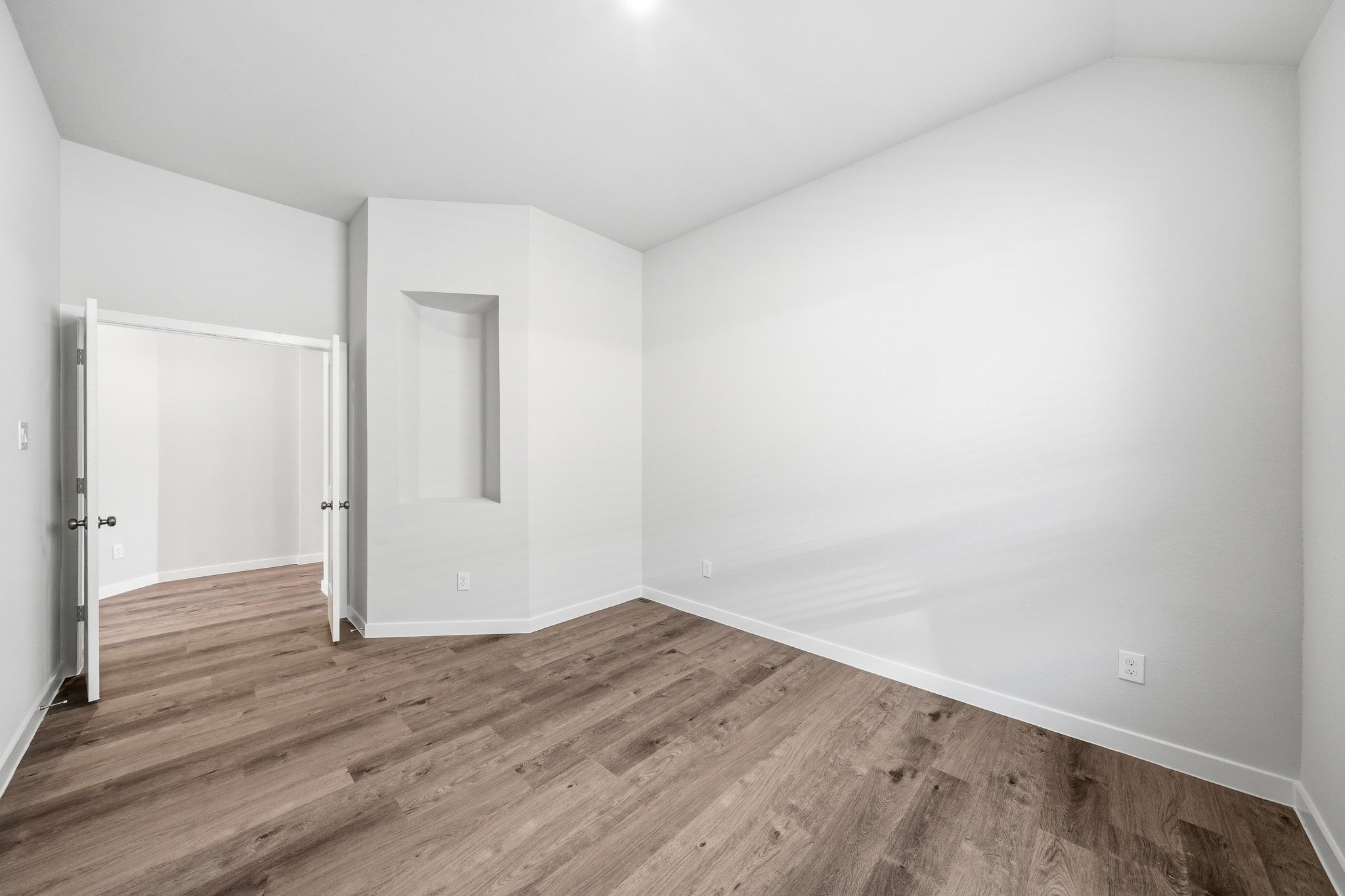 A room with a wood floor and white walls.