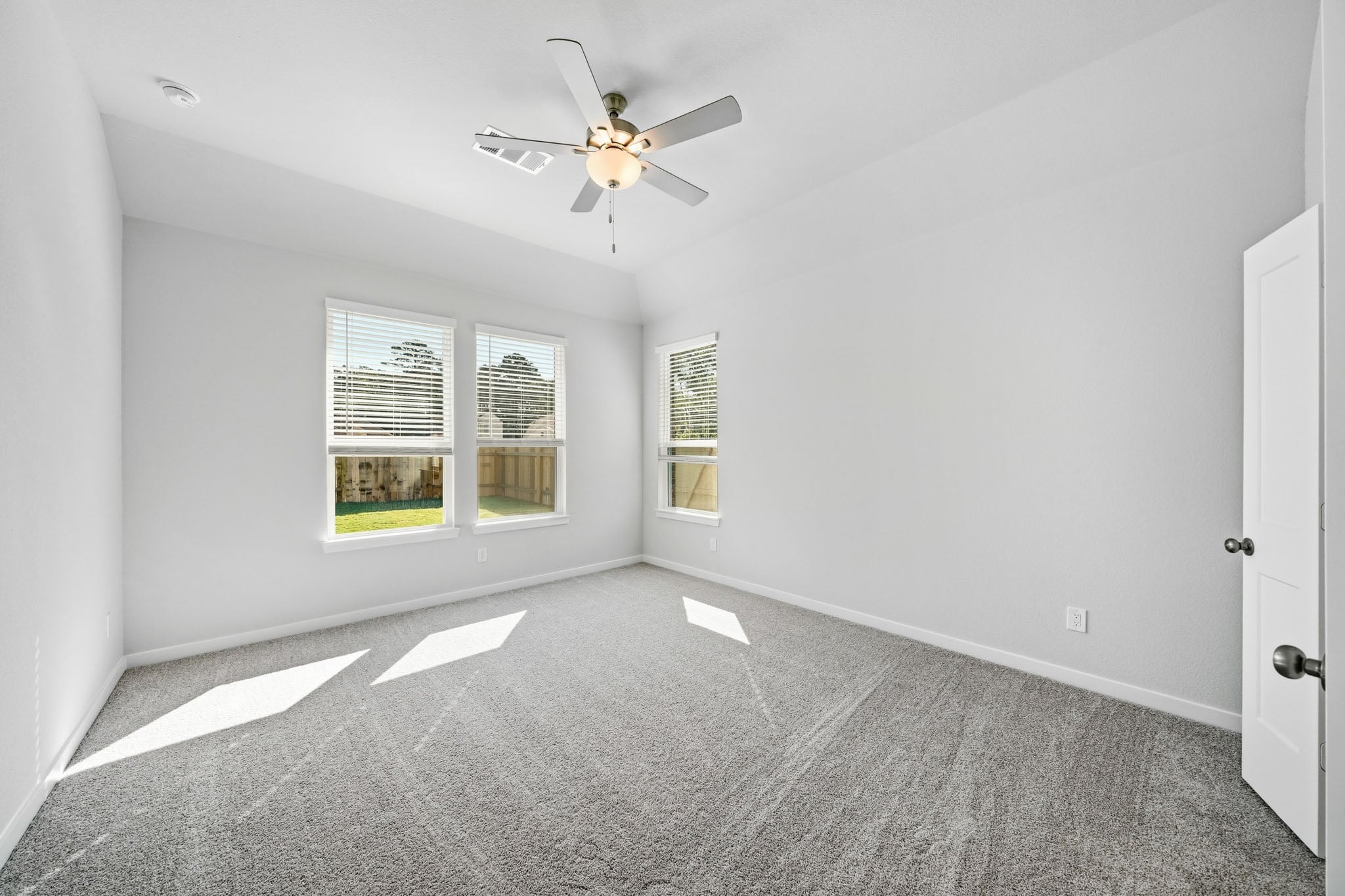 A room with a ceiling fan and a window.