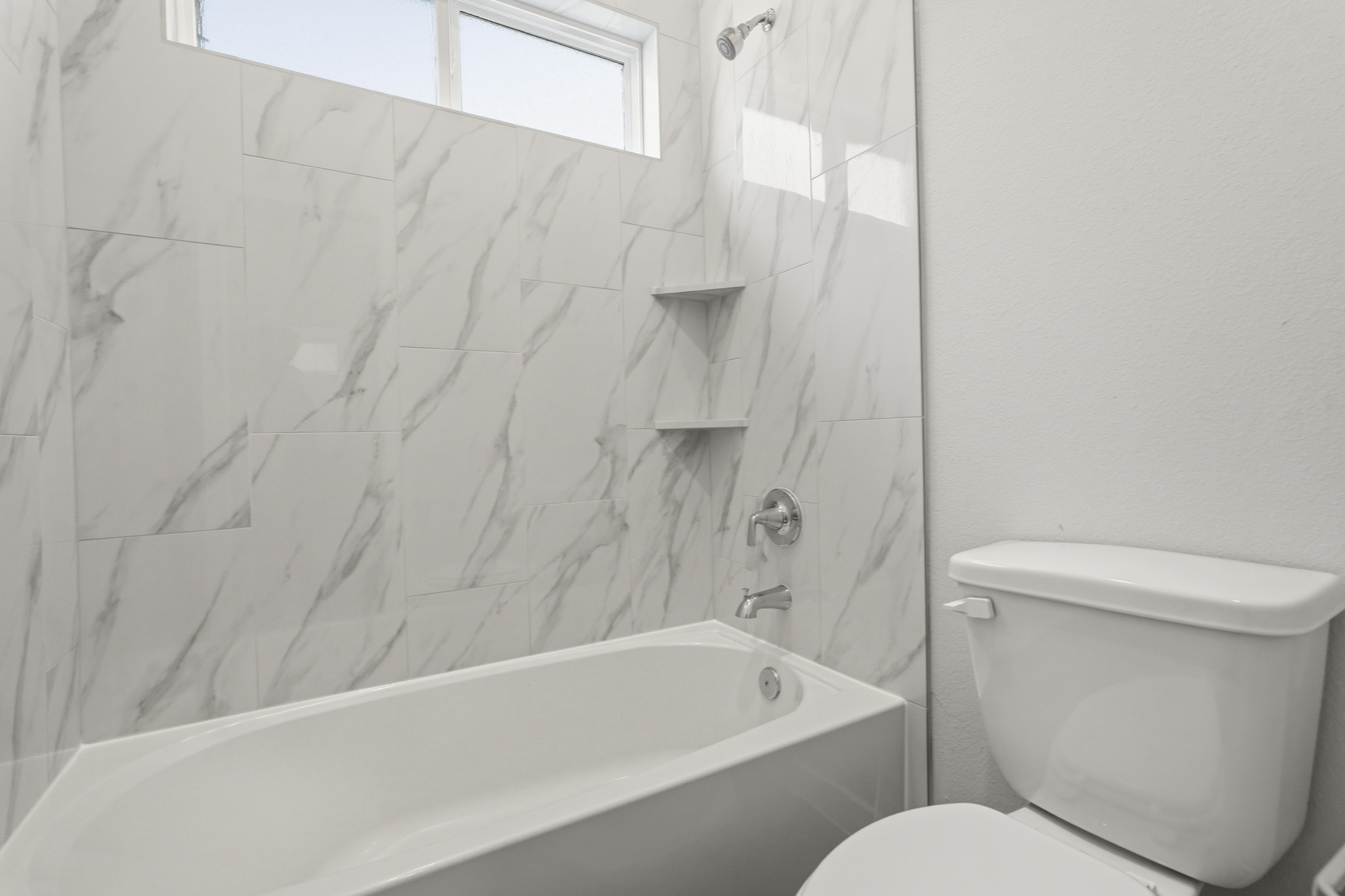 A bathroom with a bathtub and toilet.