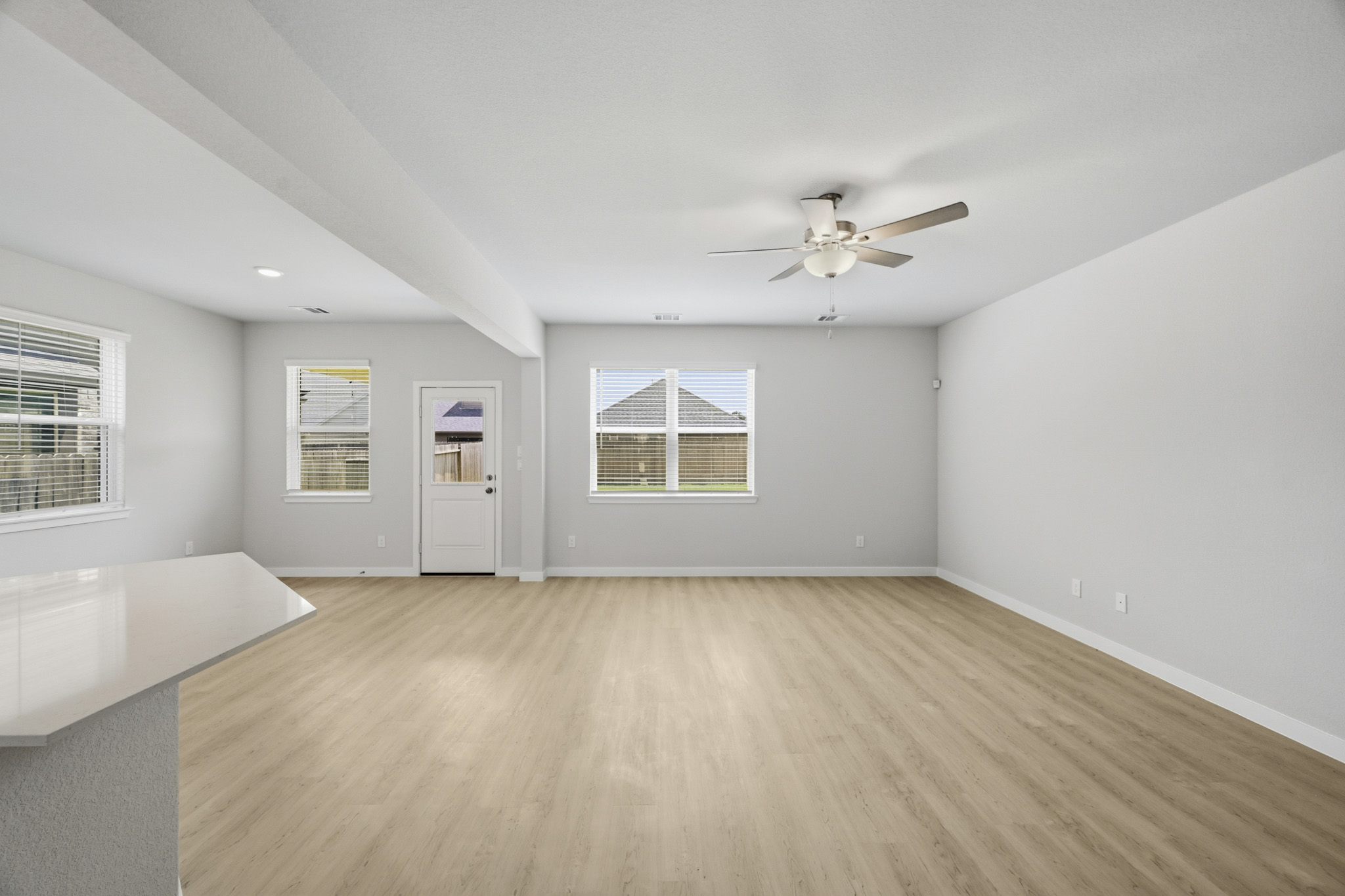 A room with a wood floor and a ceiling fan.